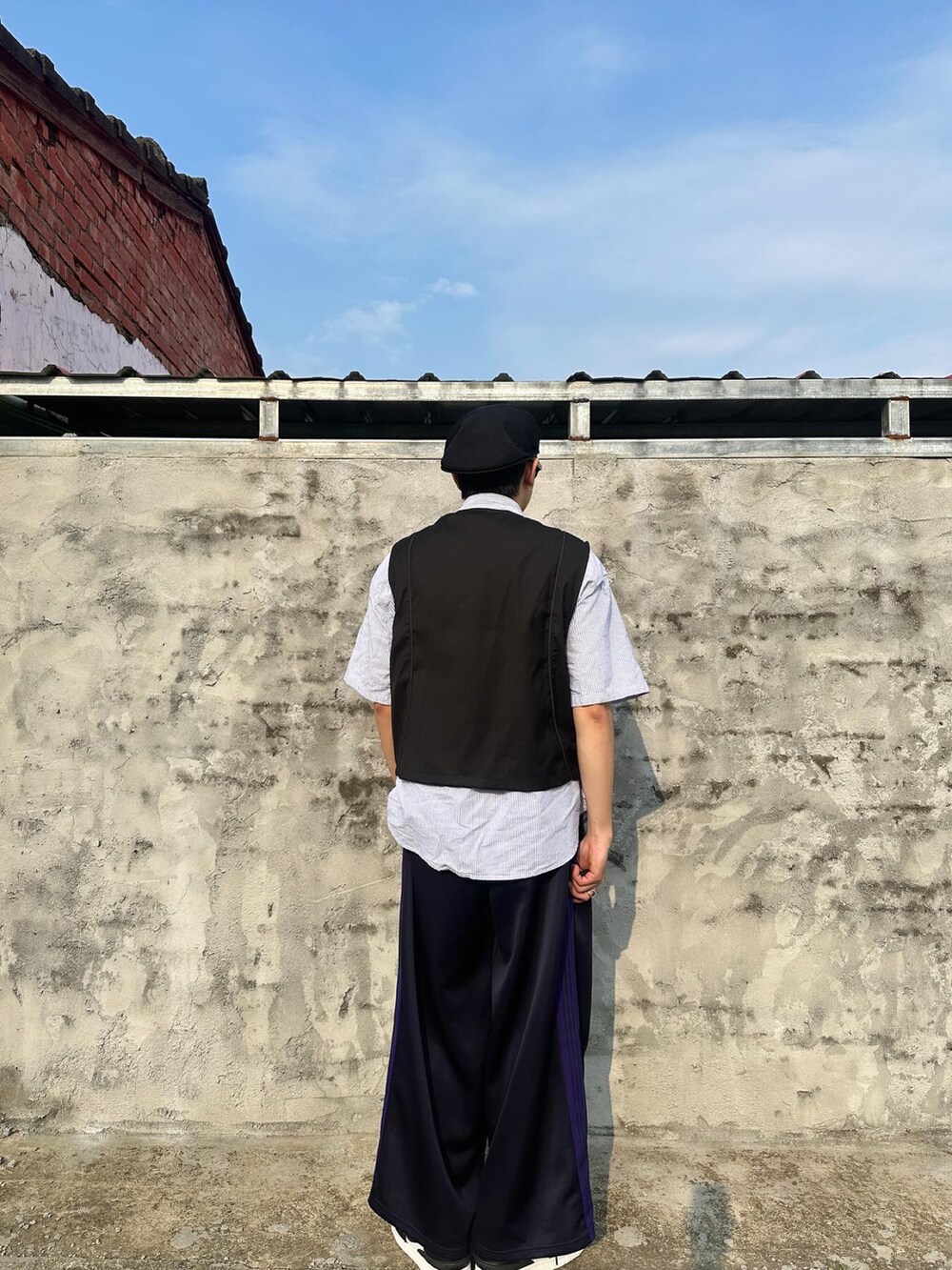 ブラック系のスーツベスト、ブルー系のその他パンツ、ブラック系のスニーカーを着用したメンズの春コーディネートの5枚目の写真