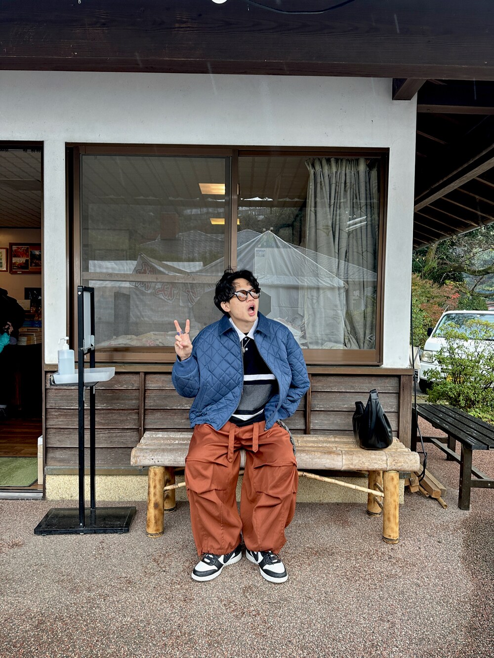 ブラック系のポロシャツ、ブルー系のジャケット/アウター、オレンジ系のパンツを着用したメンズの冬コーディネートの3枚目の写真