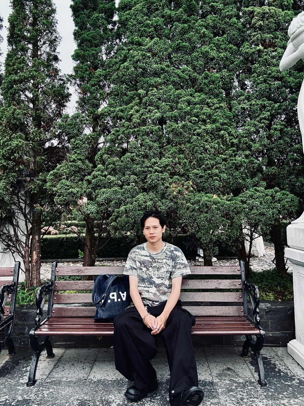 グリーン系のTシャツ/カットソー、ブラック系のパンツ、ブルー系のトートバッグを着用したメンズの夏コーディネートの2枚目の写真