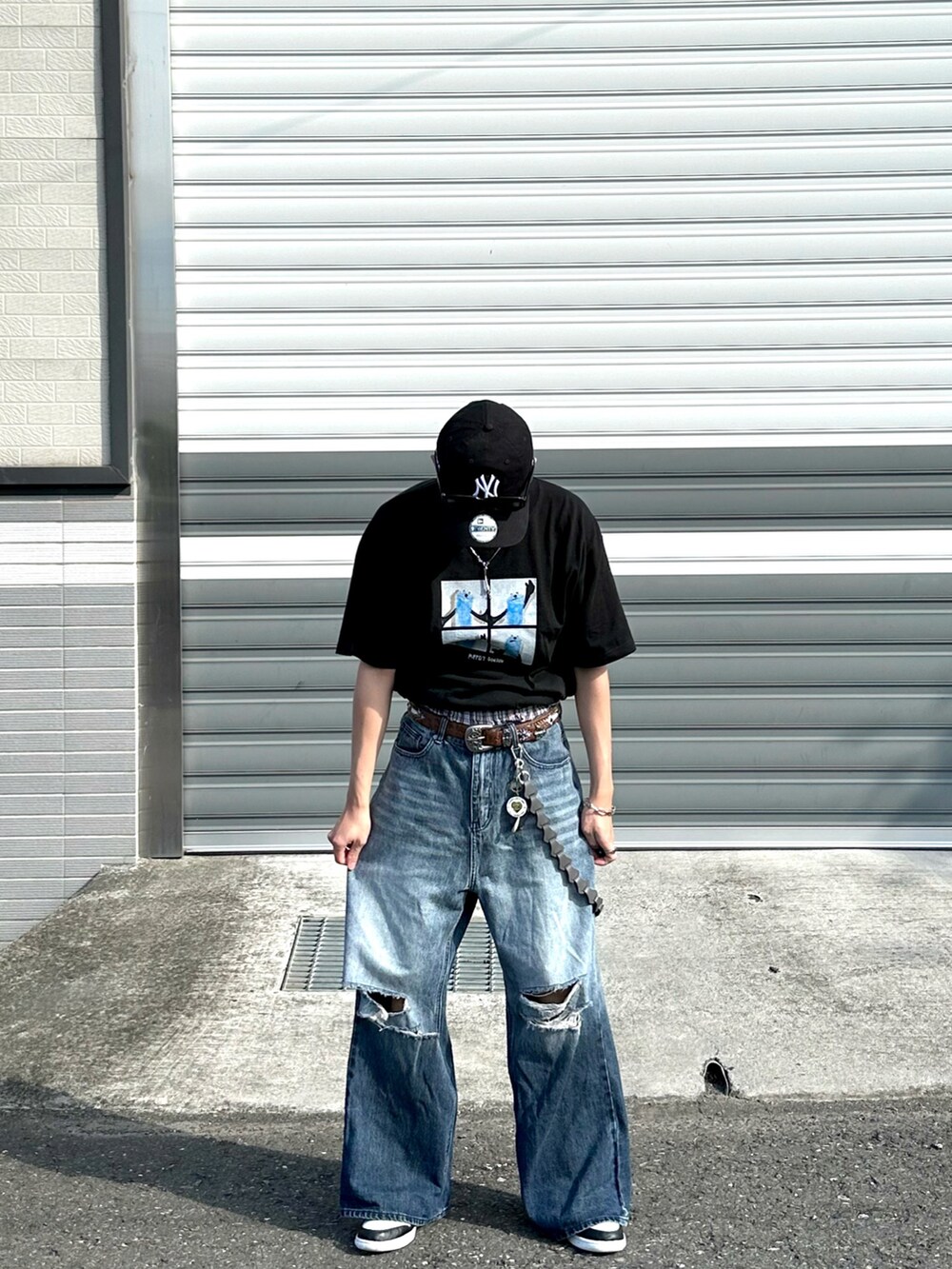 ブラック系のTシャツ/カットソー、ブルー系のデニムパンツ、ブラック系のスニーカーを着用したメンズの夏コーディネートの3枚目の写真