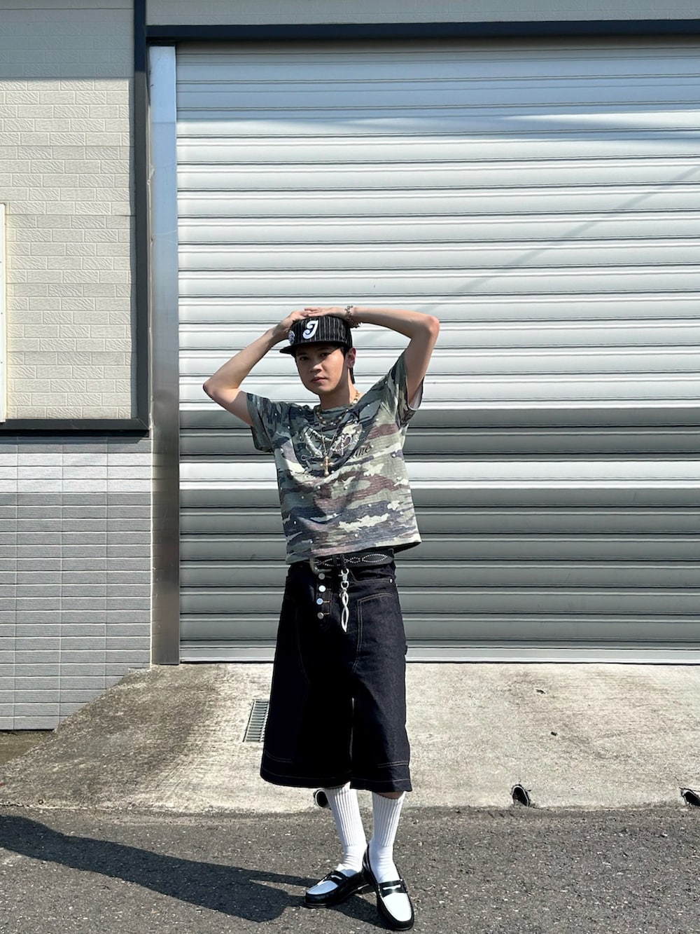 グリーン系のTシャツ/カットソー、ブラック系のデニムパンツ、ブラック系のローファーを着用したメンズの夏コーディネートの2枚目の写真