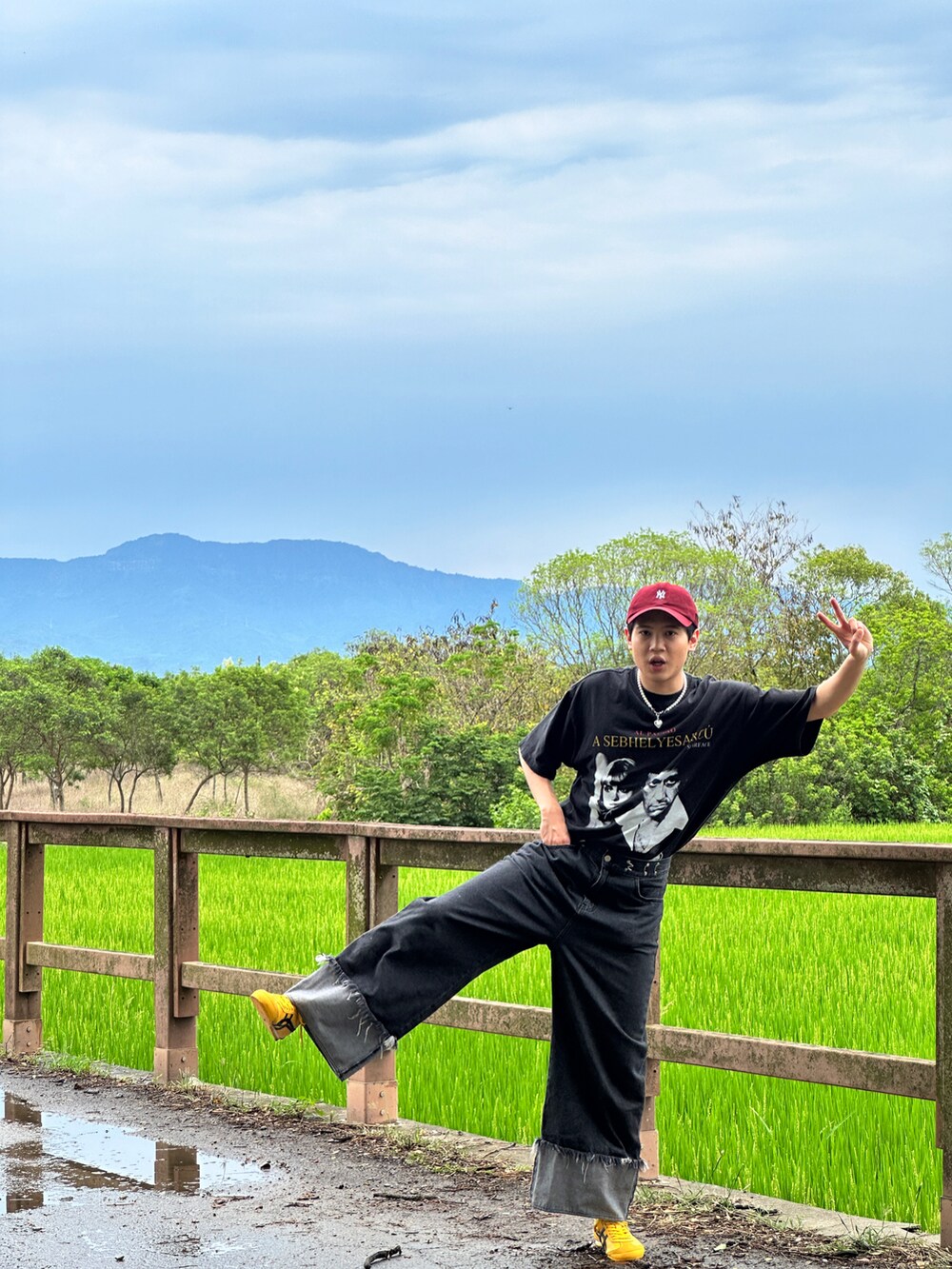 ブラック系のデニムパンツ、イエロー系のスニーカー、シルバー系のアクセサリーを着用したメンズの夏コーディネートの5枚目の写真