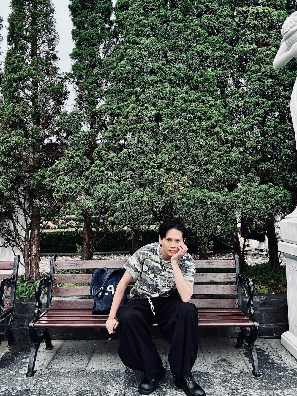 グリーン系のTシャツ/カットソー、ブラック系のパンツ、ブルー系のトートバッグを着用したメンズの夏コーディネートの3枚目の写真