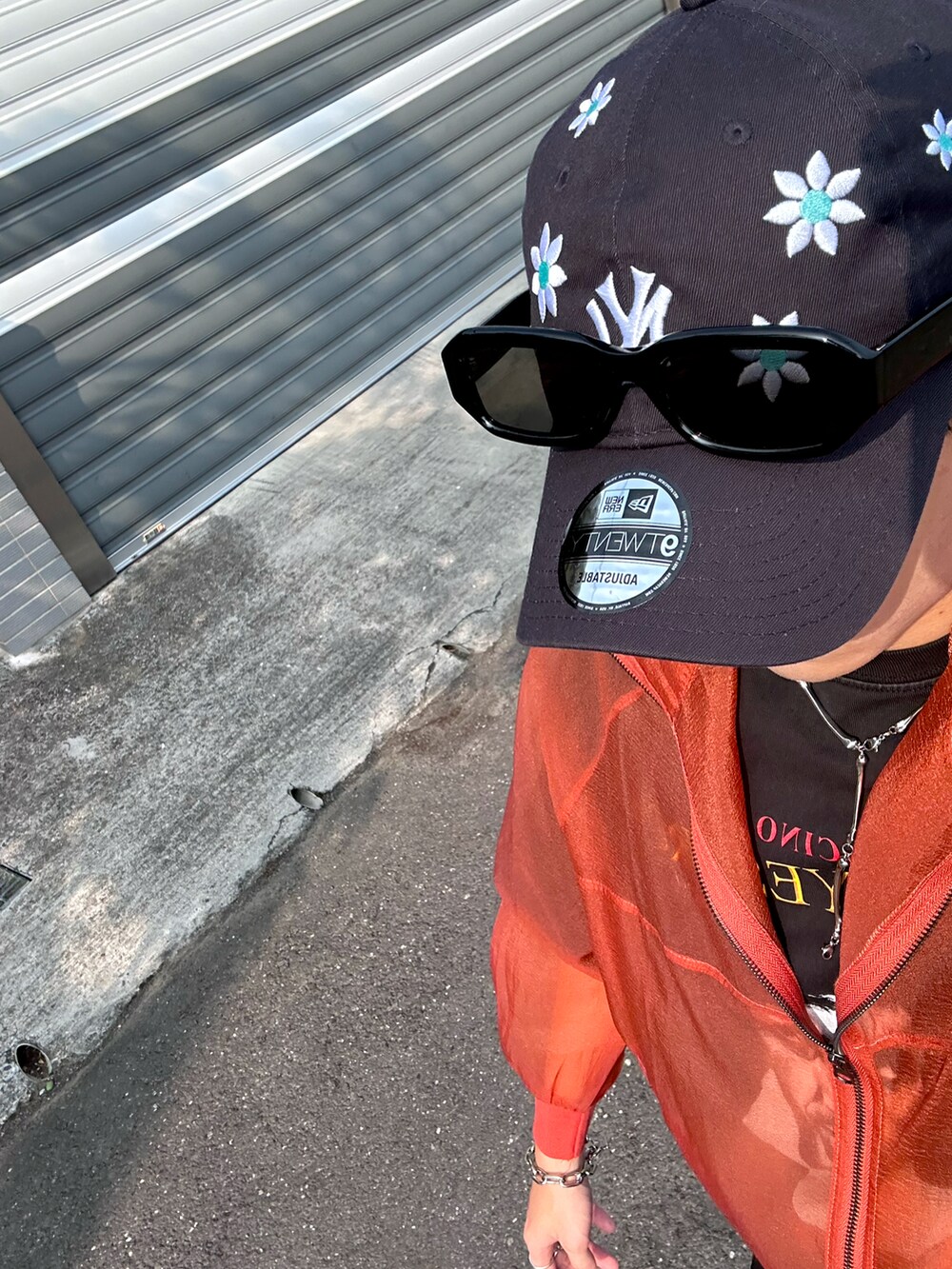 オレンジ系のジャケット/アウター、ブラック系のパンツ、ブルー系のキャップを着用したメンズの春コーディネートの4枚目の写真