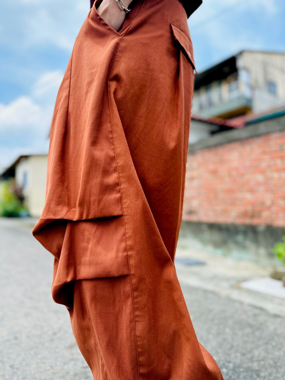 オレンジ系のパンツ、ブラック系のスニーカー、オレンジ系のサングラスを着用したメンズの夏コーディネートの4枚目の写真