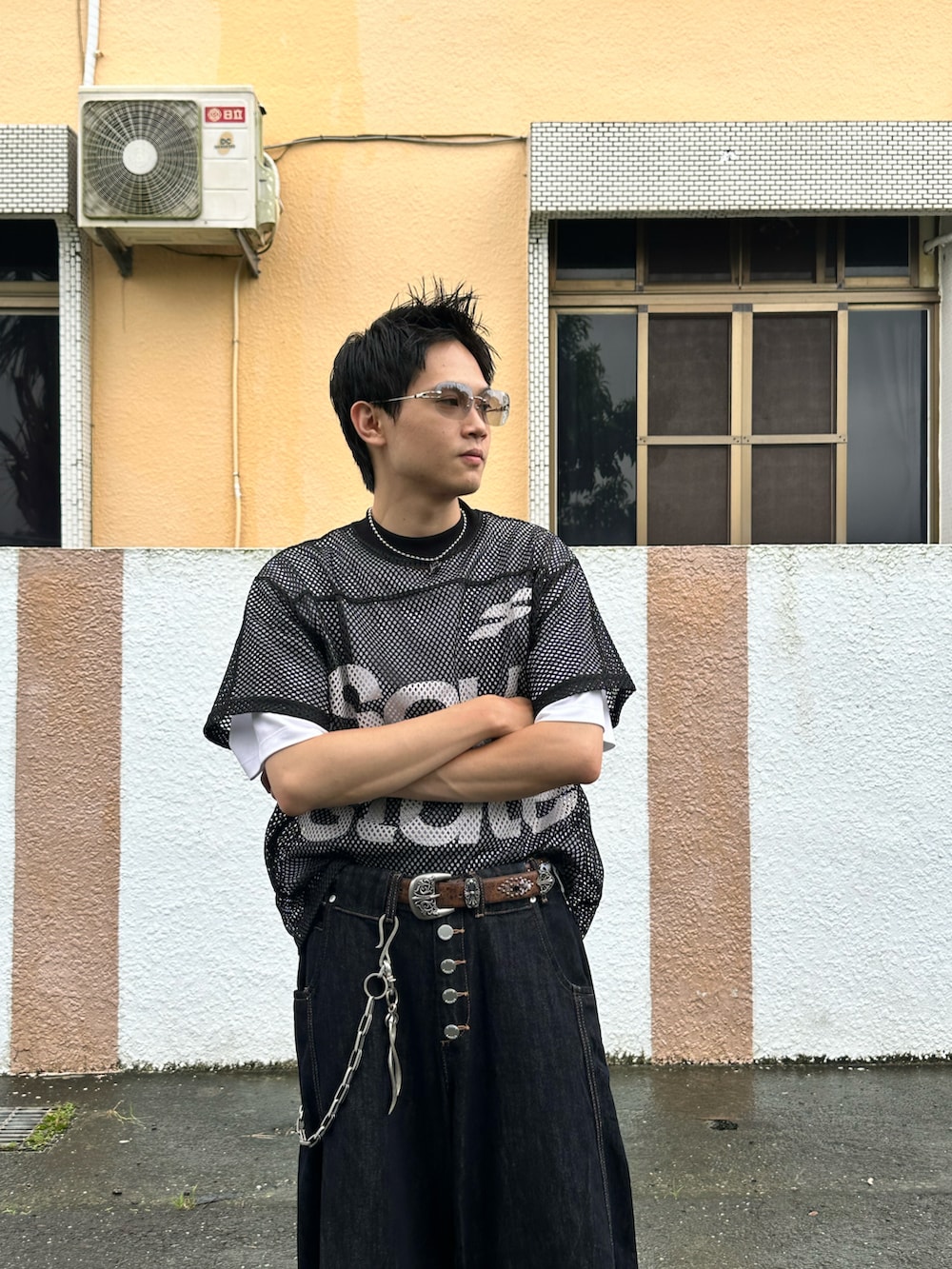 ブラック系のトップス、ブラック系のデニムパンツ、シルバー系のアクセサリーを着用したメンズの秋コーディネートの2枚目の写真