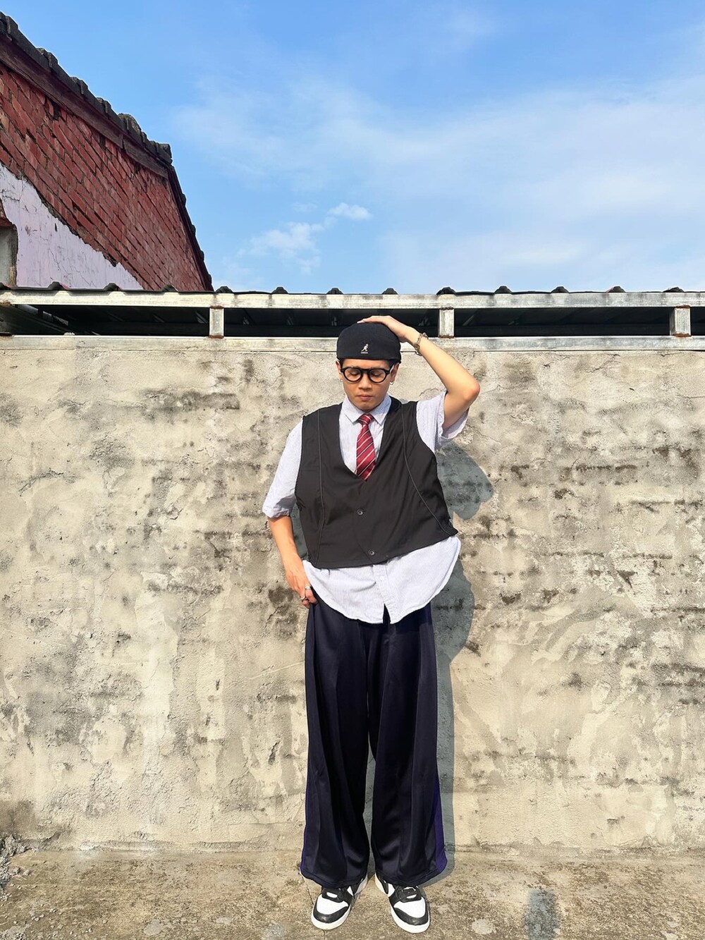 ブラック系のスーツベスト、ブルー系のその他パンツ、ブラック系のスニーカーを着用したメンズの春コーディネートの3枚目の写真