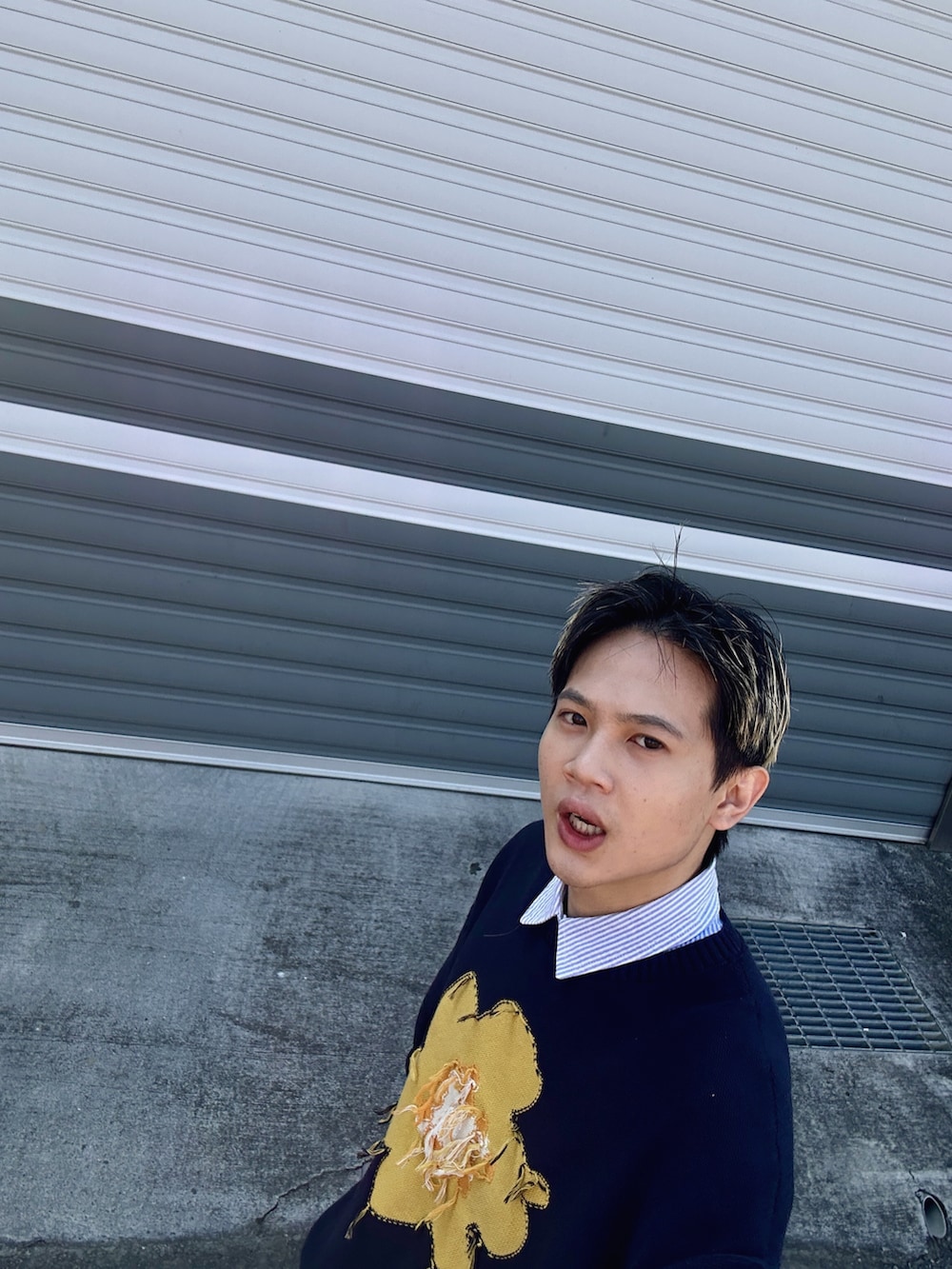 ブルー系のデニムパンツ、イエロー系のスニーカー、ブルー系のニット/セーターを着用したメンズの冬コーディネートの3枚目の写真