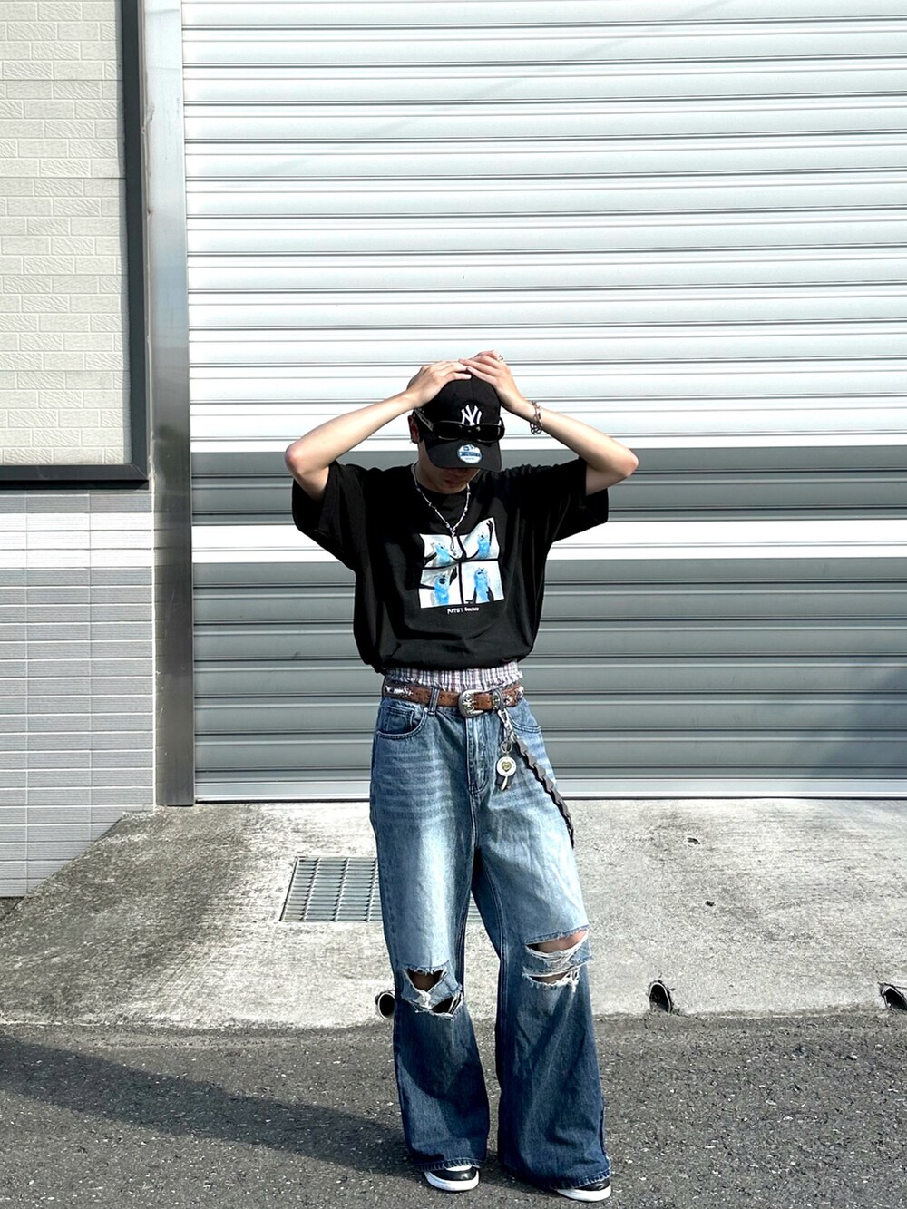 ブラック系のTシャツ/カットソー、ブルー系のデニムパンツ、ブラック系のスニーカーを着用したメンズの夏コーディネートの2枚目の写真