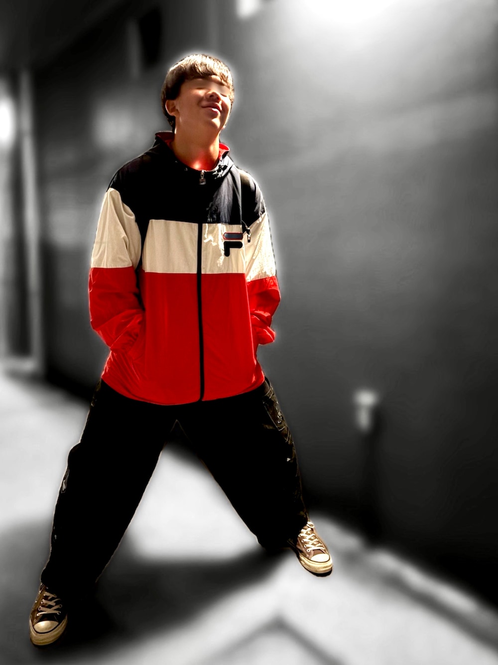 ブラウン系のTシャツ/カットソー、レッド系のナイロンジャケット、ブラック系のデニムパンツを着用したメンズの秋コーディネートの2枚目の写真