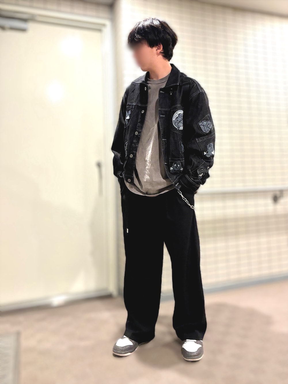 ホワイト系のスニーカー、ブラック系のスラックス、ブラック系のデニムジャケットを着用したメンズの秋コーディネートの2枚目の写真