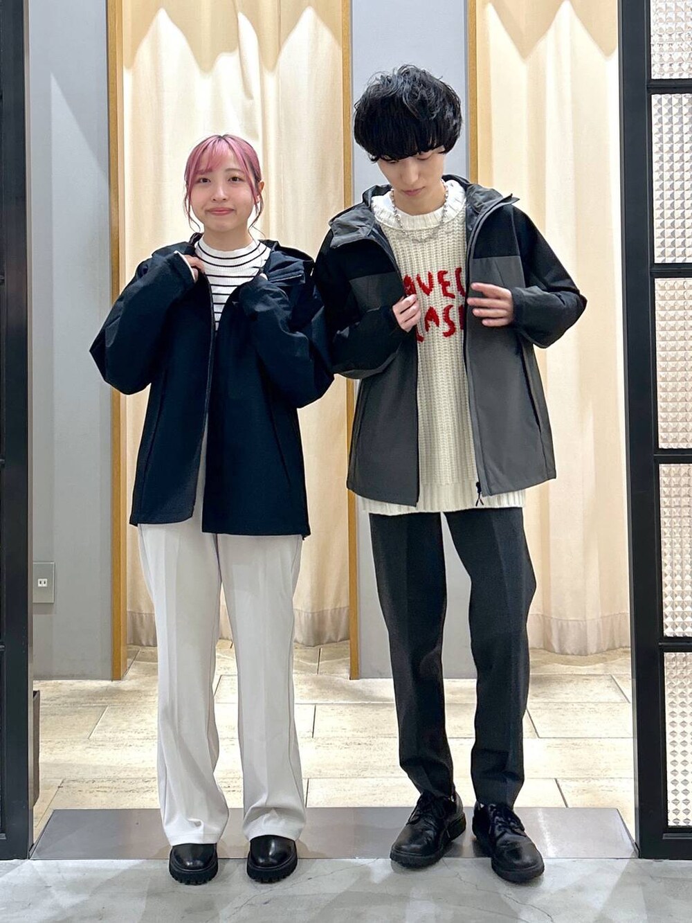 グレー系のスラックス、ブラック系のブーツ、ホワイト系のニット/セーターを着用したレディースの冬コーディネートの5枚目の写真