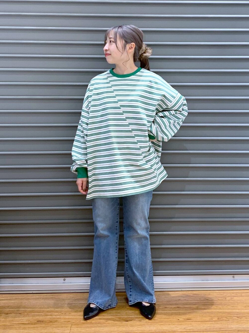 グリーン系のワンピース、ブルー系のデニムパンツ、ブラック系のパンプスを着用したレディースの春コーディネートの4枚目の写真