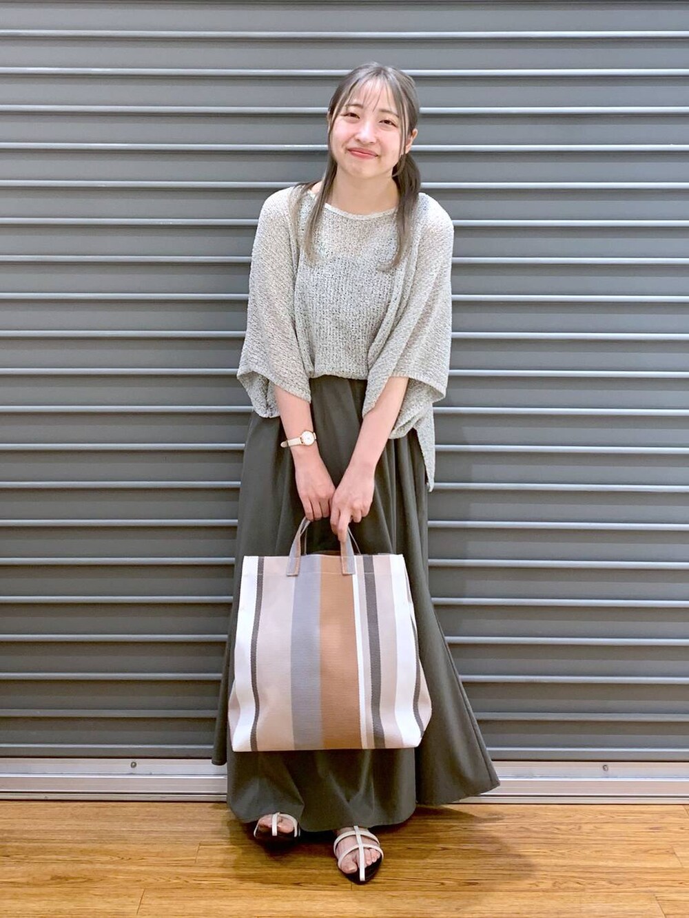 ベージュ系のニット/セーター、ホワイト系のサンダル、ベージュ系のトートバッグを着用したレディースの夏コーディネートの5枚目の写真