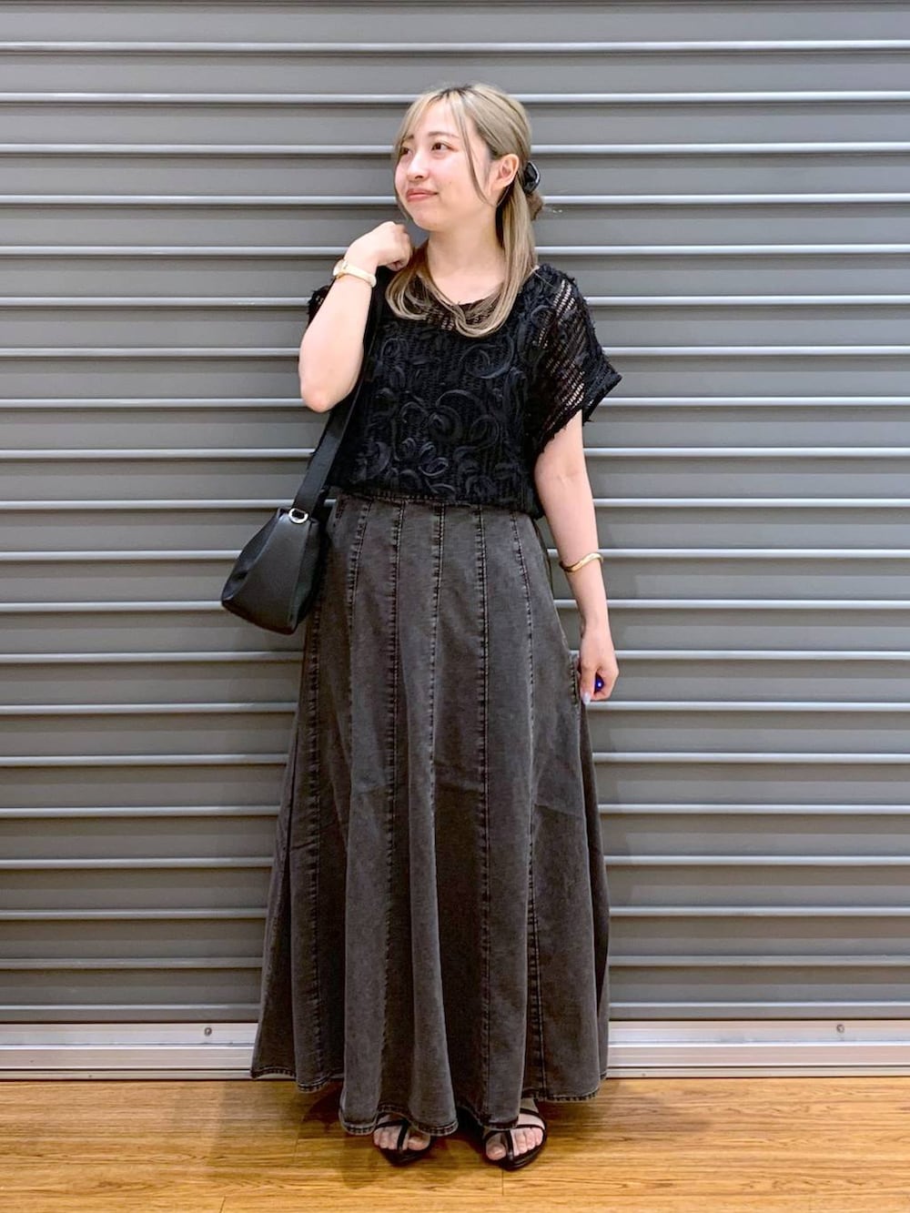 ブラック系のショルダーバッグ、グレー系のスカート、ブラック系のサンダルを着用したレディースの夏コーディネートの7枚目の写真
