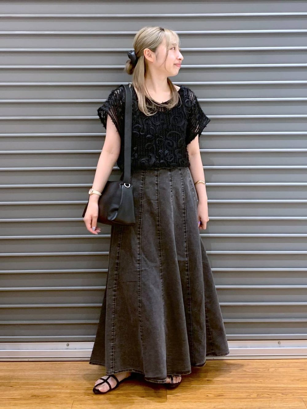 ブラック系のショルダーバッグ、グレー系のスカート、ブラック系のサンダルを着用したレディースの夏コーディネートの5枚目の写真