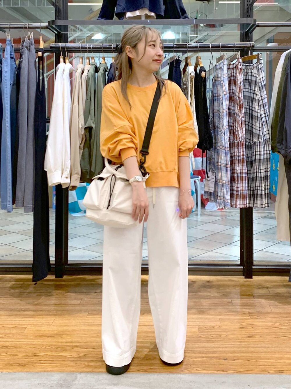 ホワイト系のショルダーバッグ、ホワイト系のデニムパンツ、ブラック系のサンダルを着用したレディースの春コーディネートの5枚目の写真