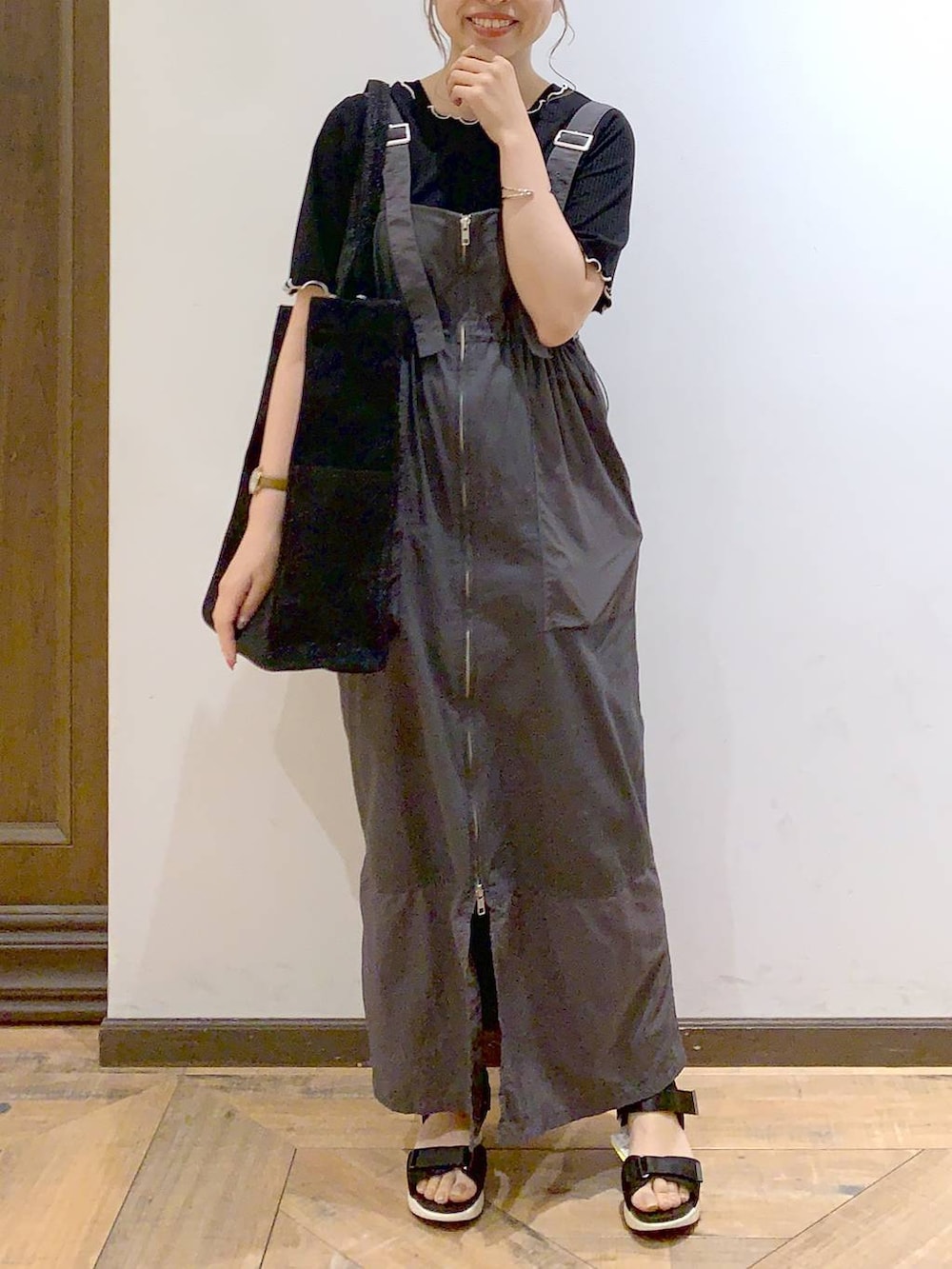 ブラック系のトートバッグ、ブラック系のサンダル、ブラック系のTシャツ/カットソーを着用したレディースの夏コーディネートの3枚目の写真