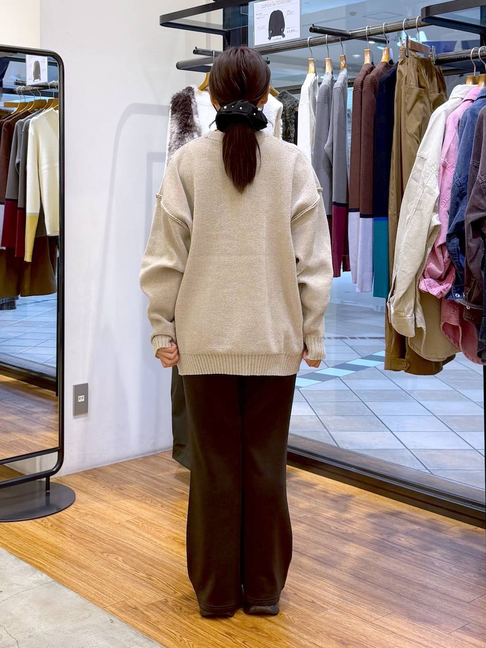 ブラック系のスニーカー、ブラック系のその他パンツ、ホワイト系のニット/セーターを着用したレディースの秋コーディネートの2枚目の写真