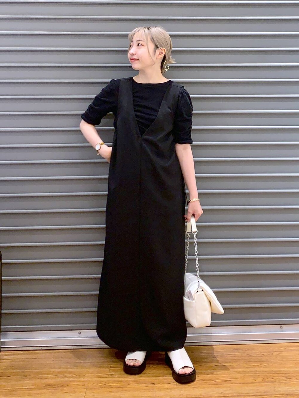 ホワイト系のショルダーバッグ、ホワイト系のサンダル、ブラック系のワンピースを着用したレディースの夏コーディネートの5枚目の写真