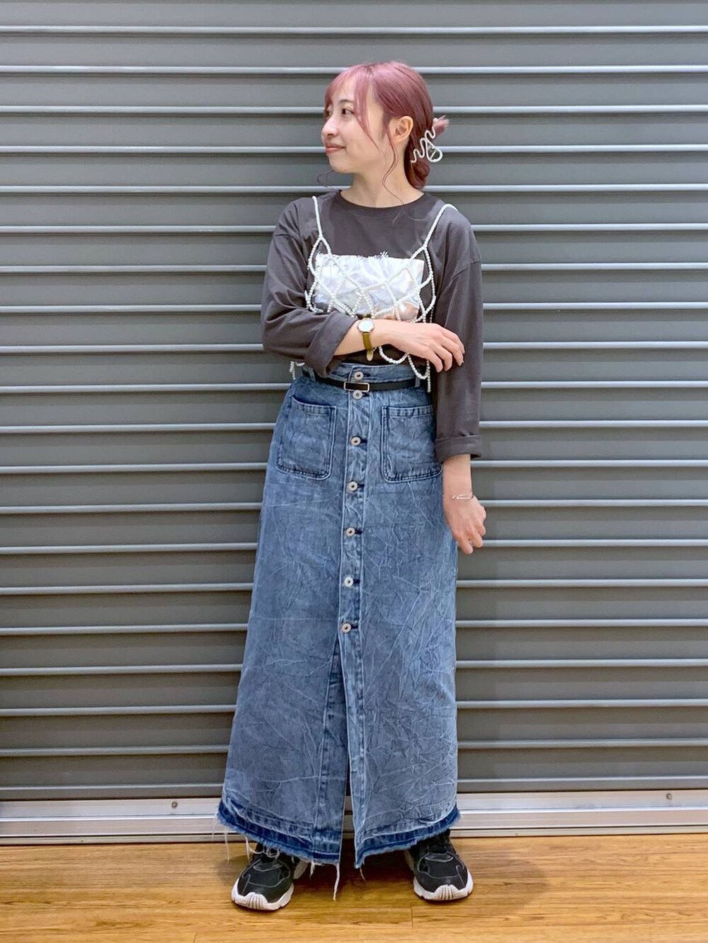 ホワイト系のベスト、ブルー系のデニムスカート、グレー系のTシャツ/カットソーを着用したレディースの秋コーディネートの3枚目の写真