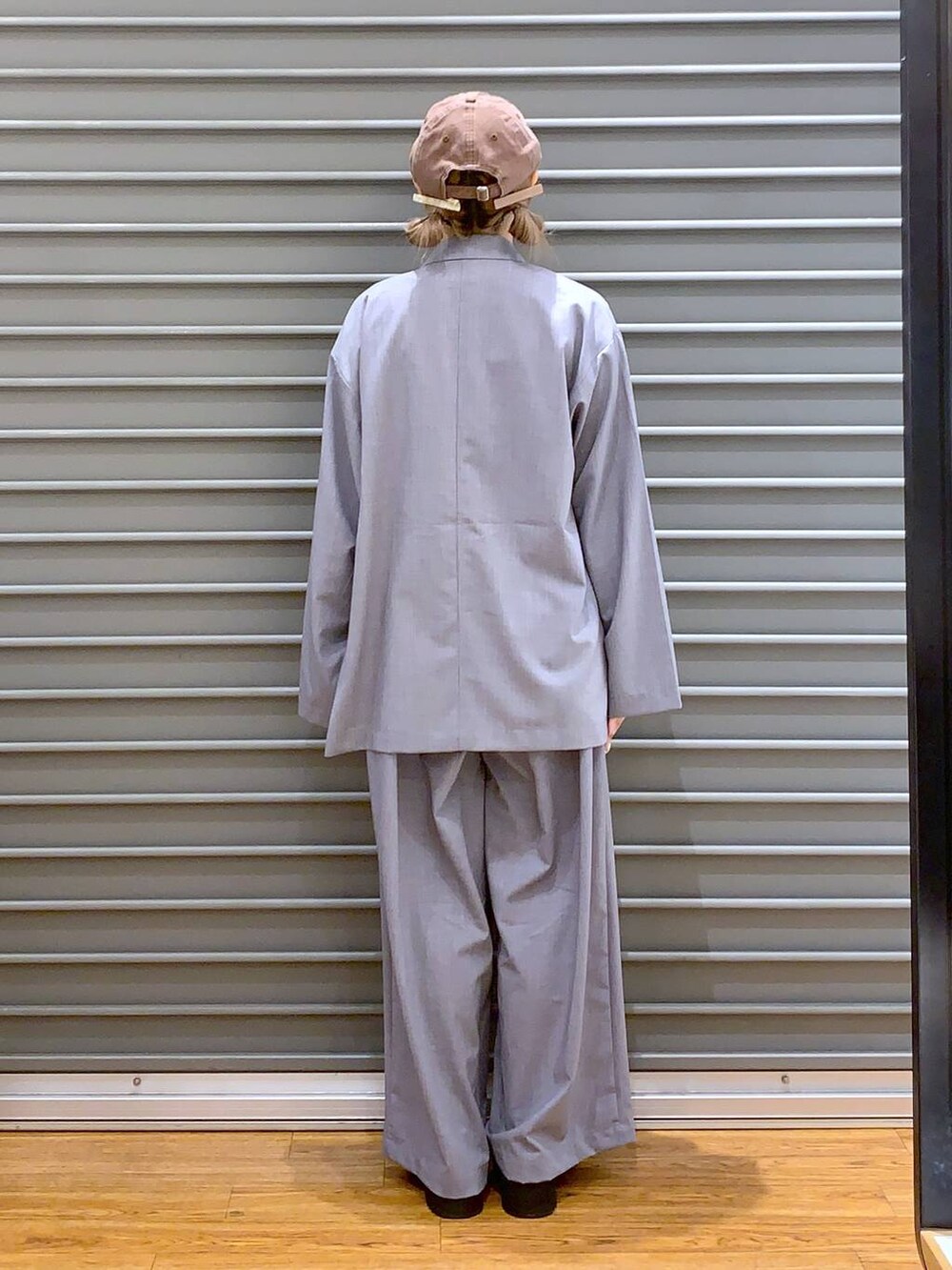 グレー系のスラックス、ブラック系のローファー、グレー系のテーラードジャケットを着用したレディースの夏コーディネートの2枚目の写真