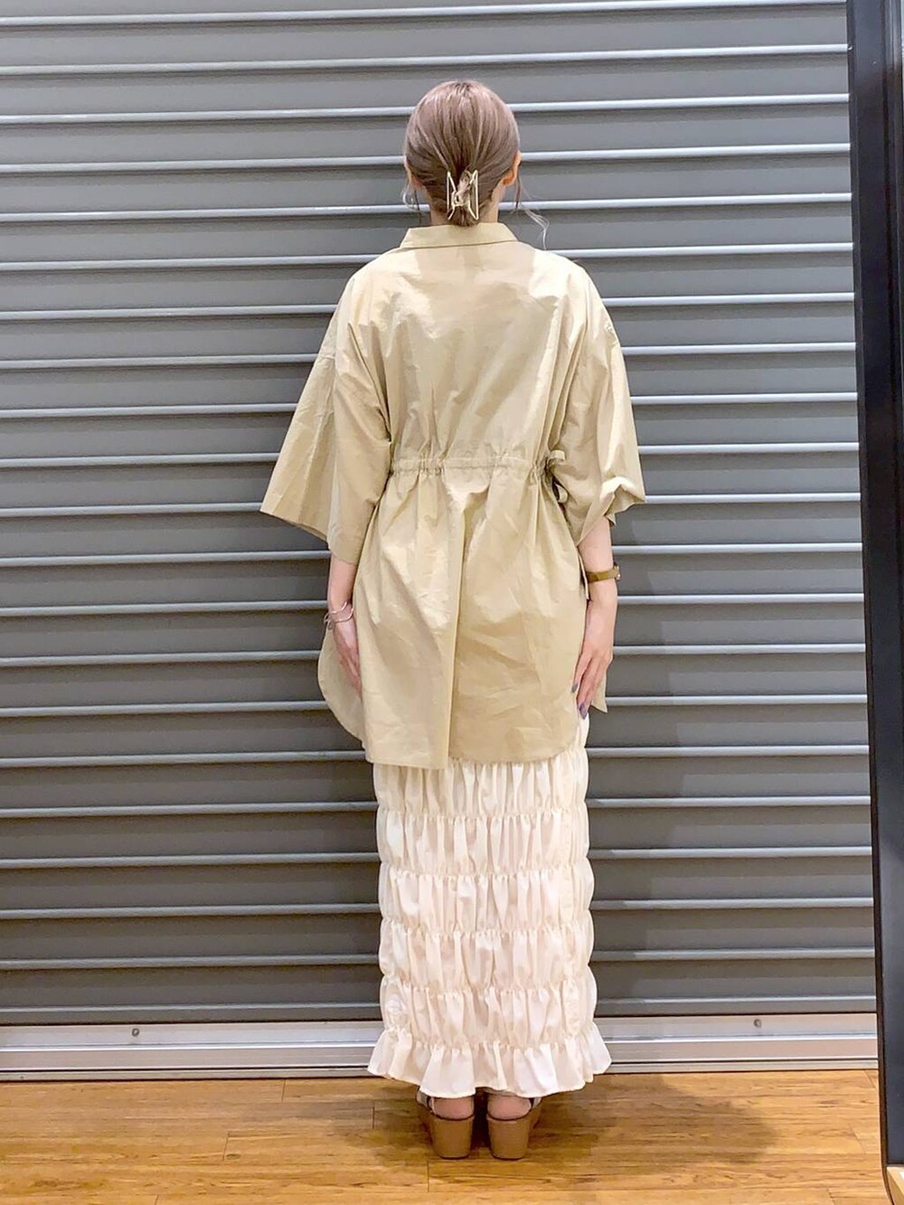 ベージュ系のその他トップス、ホワイト系のスカート、シルバー系のサンダルを着用したレディースの夏コーディネートの2枚目の写真