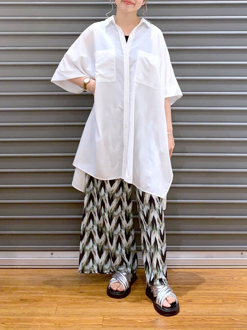 シルバー系のサンダル、ベージュ系のショルダーバッグ、ホワイト系のチュニックを着用したレディースの夏コーディネートの4枚目の写真