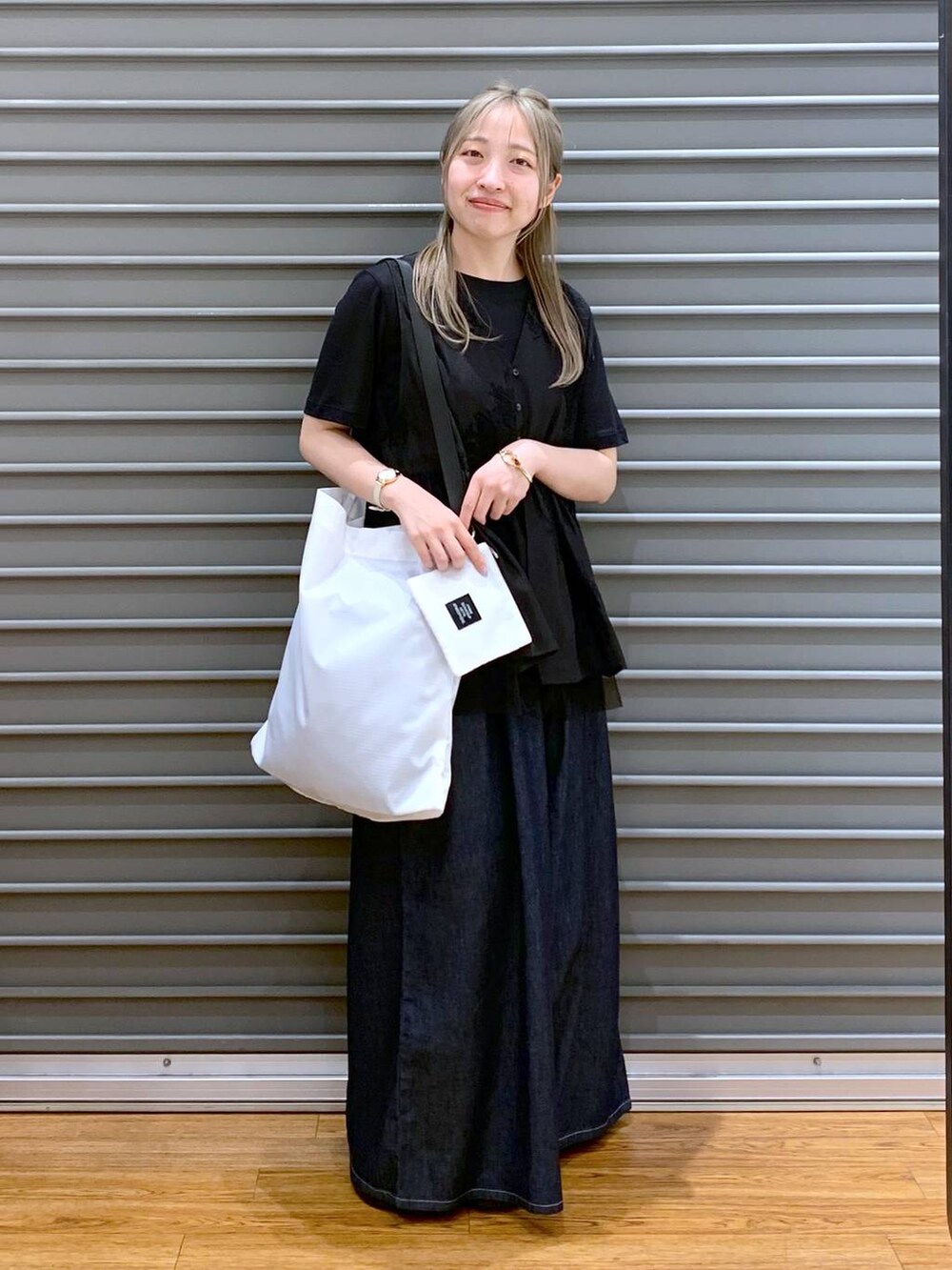 ブラック系のサンダル、ブルー系のデニムパンツ、ブラック系のシャツ/ブラウスを着用したレディースの夏コーディネートの6枚目の写真