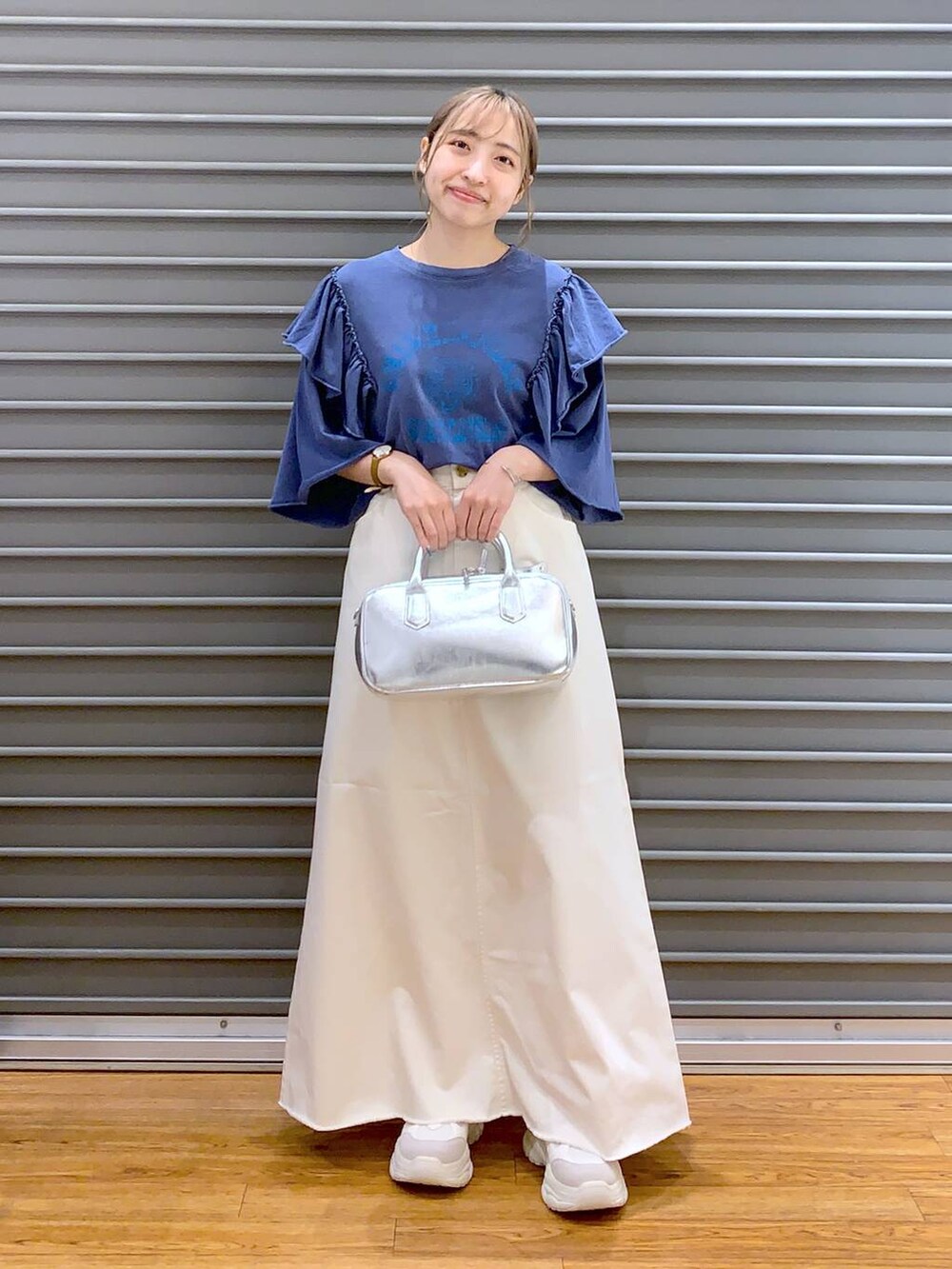 ホワイト系のスカート、ホワイト系のスニーカー、シルバー系のボストンバッグを着用したレディースの夏コーディネートの4枚目の写真