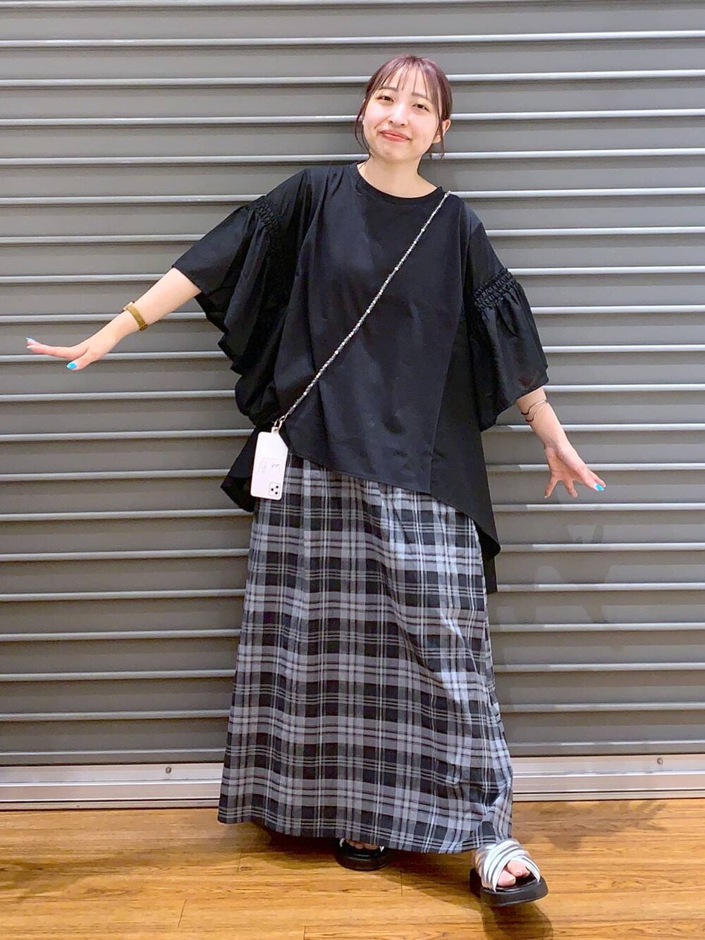 ブラック系のTシャツ/カットソー、シルバー系のサンダル、ホワイト系のスカートを着用したレディースの夏コーディネートの5枚目の写真