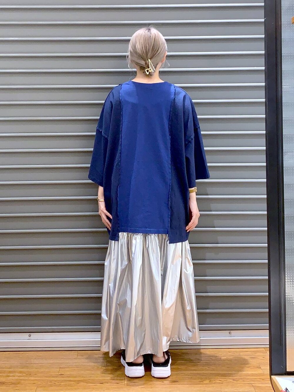 ブラック系のサンダル、シルバー系のスカート、ブルー系のTシャツ/カットソーを着用したレディースの春コーディネートの2枚目の写真