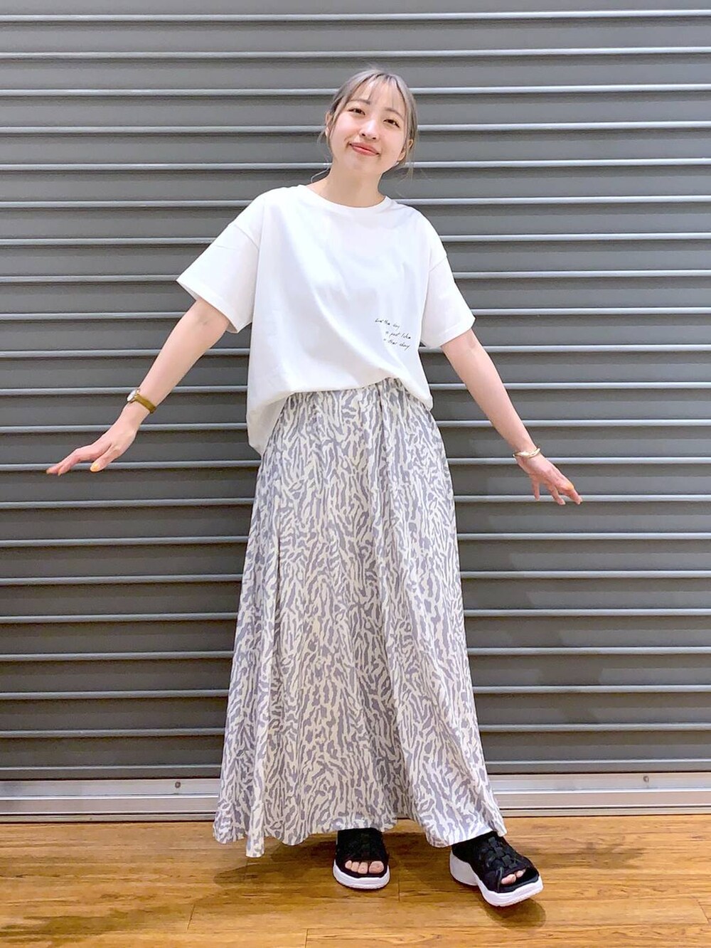 ブラック系のサンダル、ブラック系のショルダーバッグ、ホワイト系のスカートを着用したレディースの春コーディネートの3枚目の写真