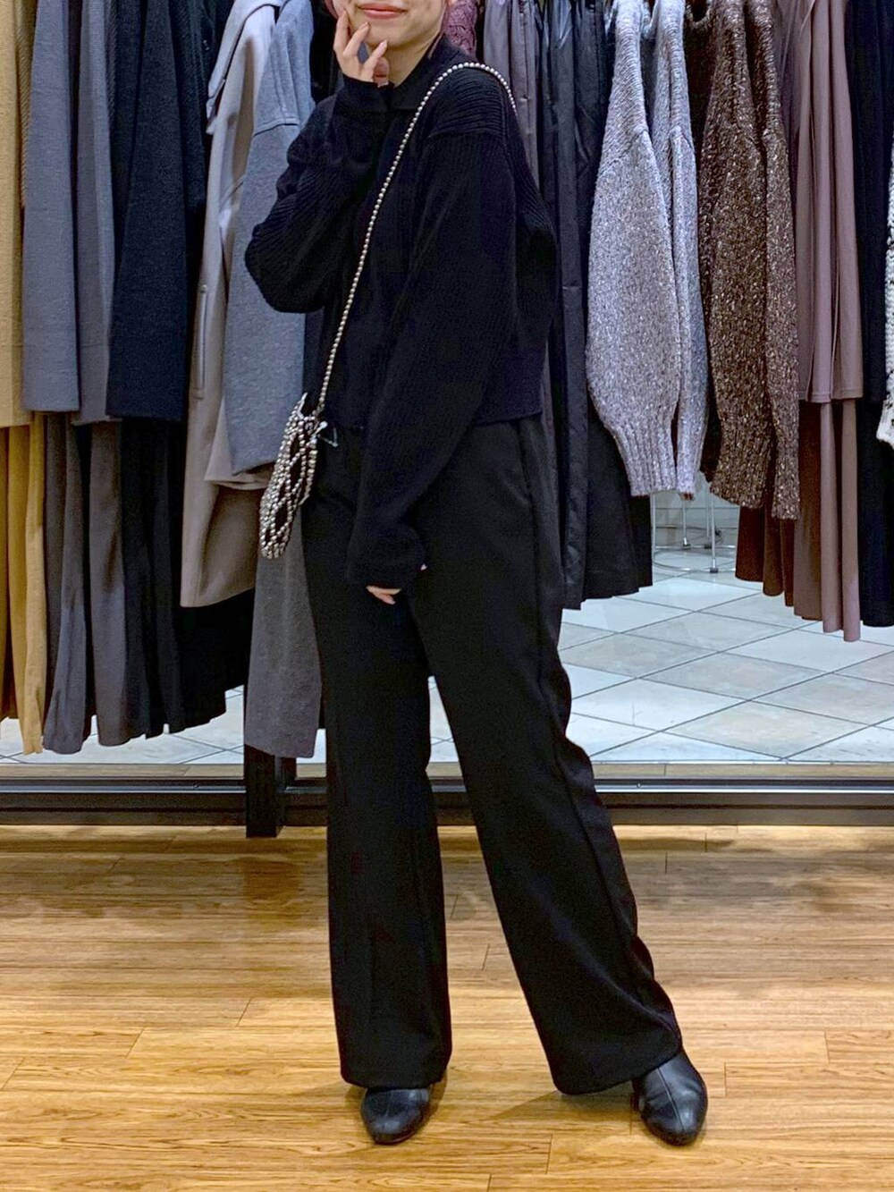 ブラック系のカーディガン/ボレロ、イエロー系のショルダーバッグ、ブラック系のスラックスを着用したレディースの秋コーディネートの3枚目の写真