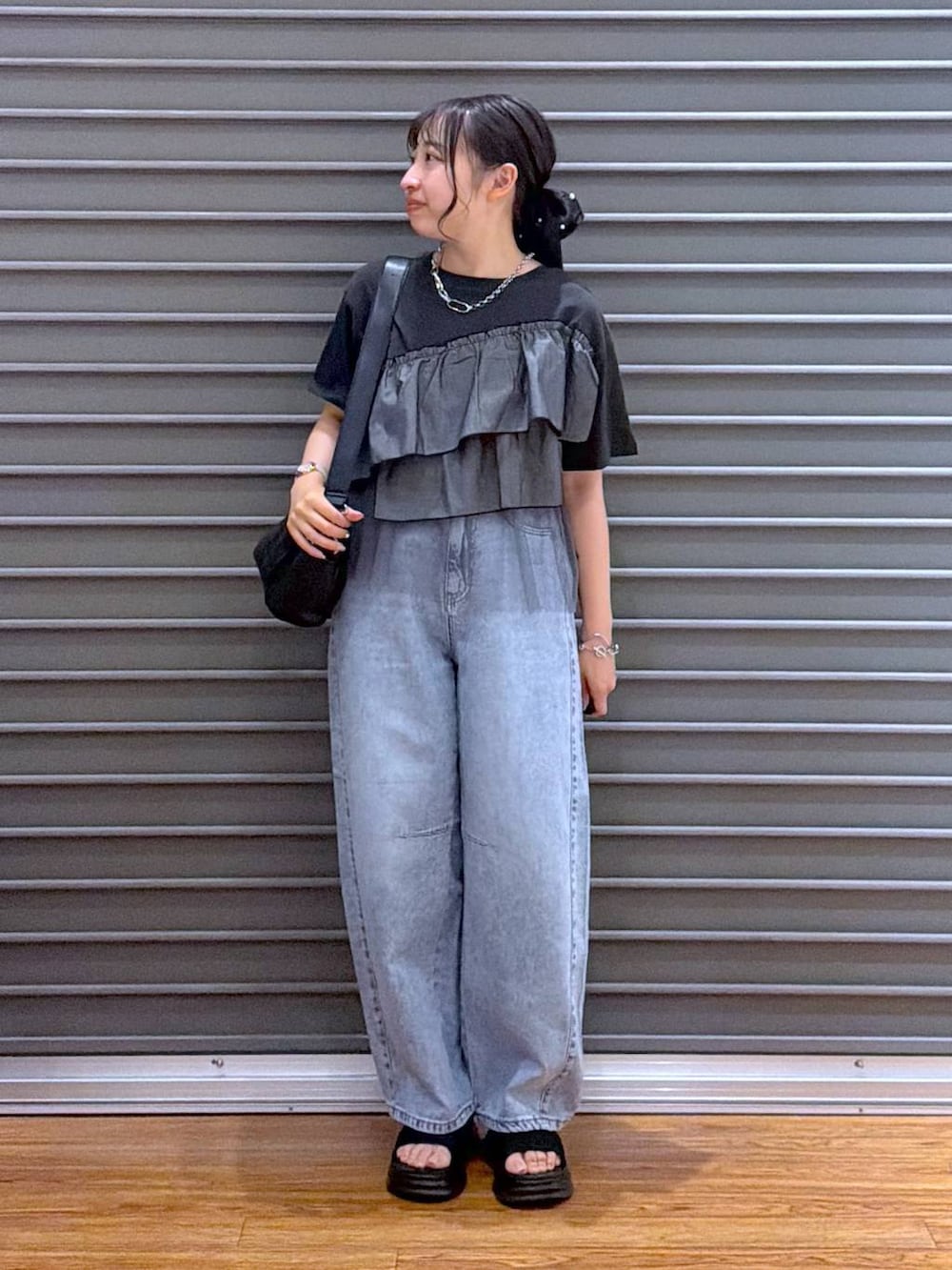 ブラック系のショルダーバッグ、ブラック系のサンダル、グレー系のTシャツ/カットソーを着用したレディースの夏コーディネートの5枚目の写真