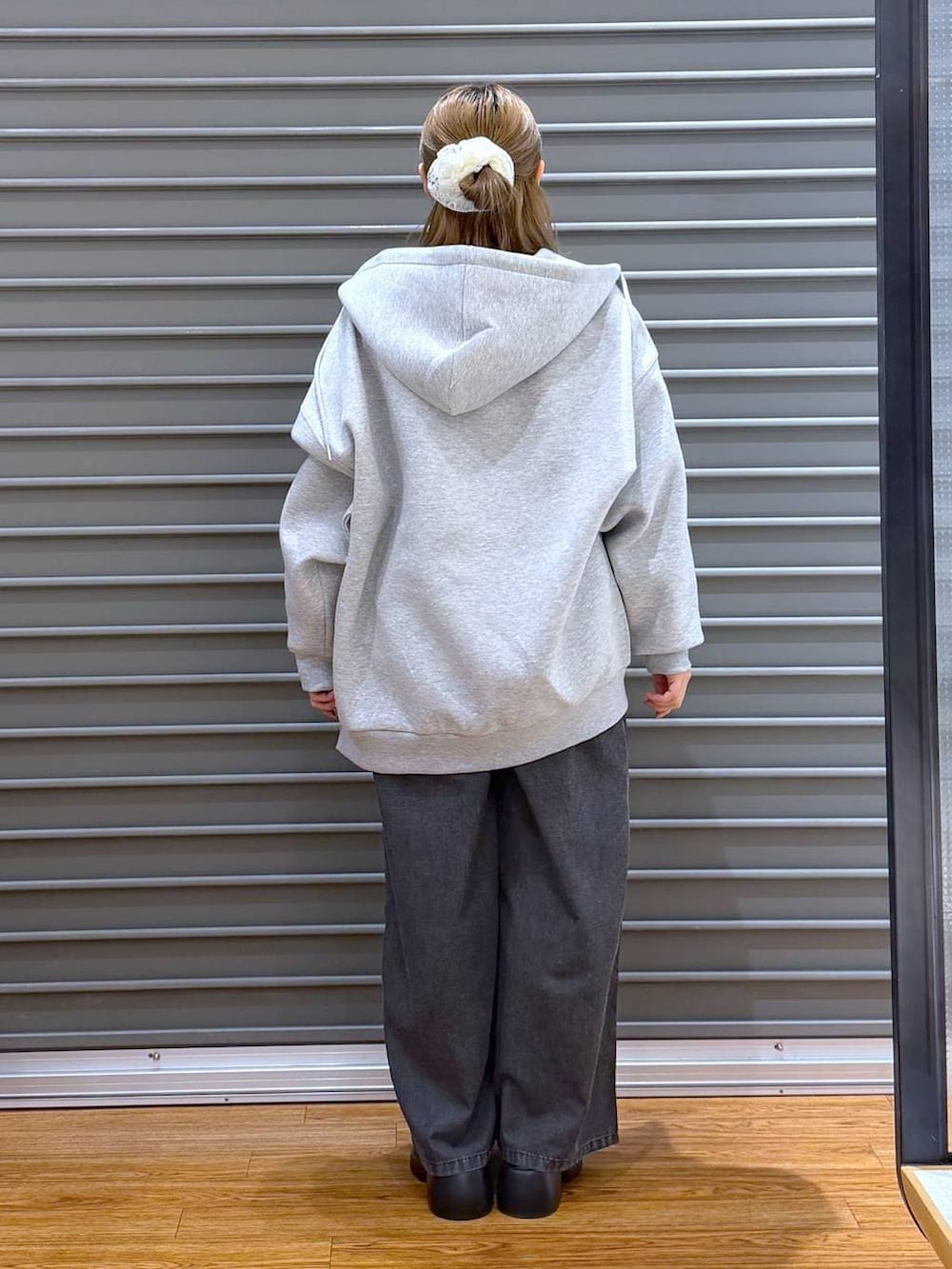 ブラック系のサンダル、ブラック系のボストンバッグ、グレー系のパーカーを着用したレディースの春コーディネートの2枚目の写真