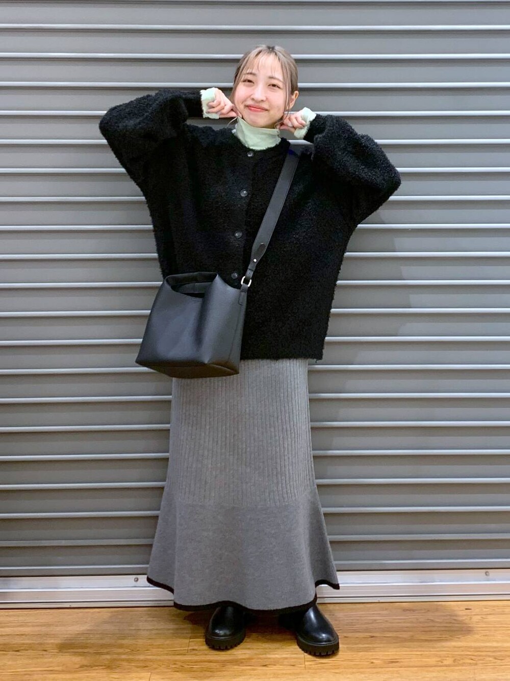 ブラック系のブーツ、ブラック系のワンピース、グリーン系のTシャツ/カットソーを着用したレディースの冬コーディネートの4枚目の写真