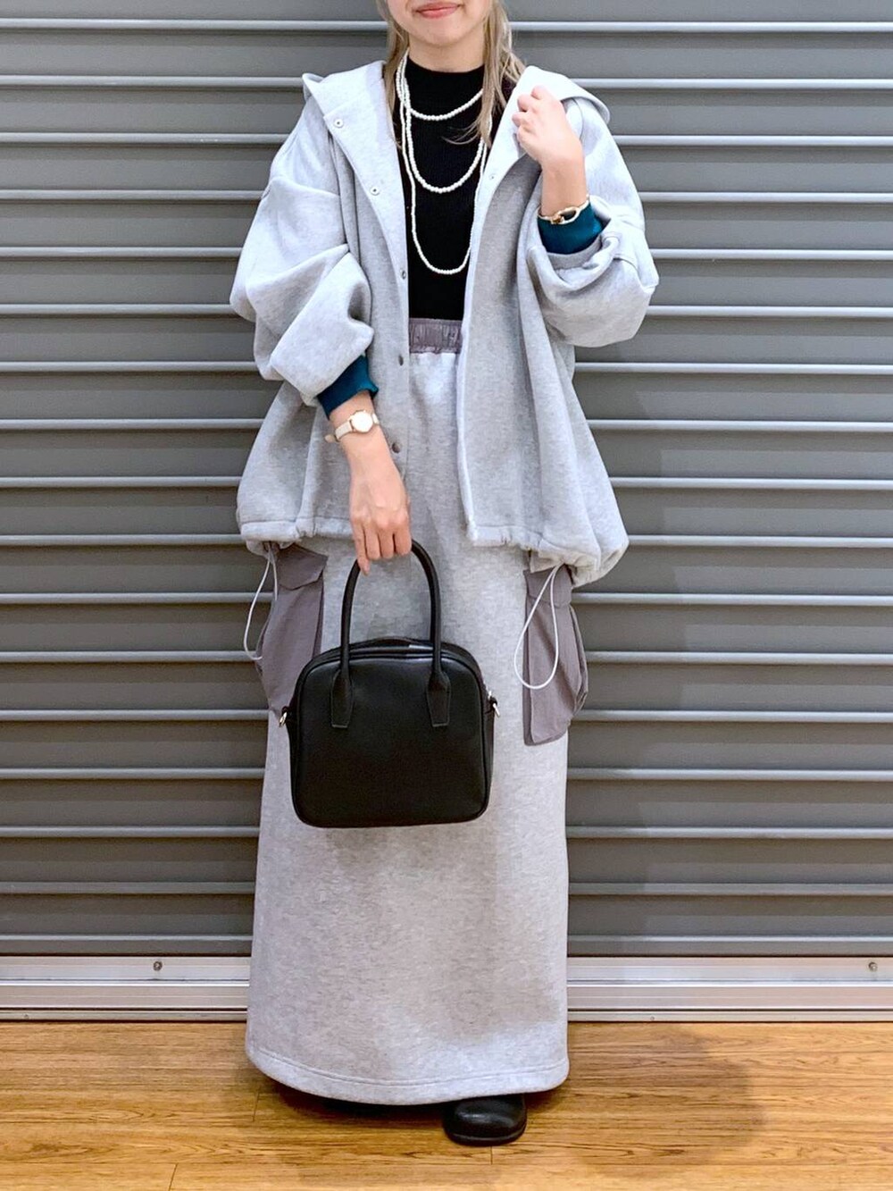 グレー系のブルゾン、ブラック系のニット/セーター、グレー系のスカートを着用したレディースの秋コーディネートの9枚目の写真