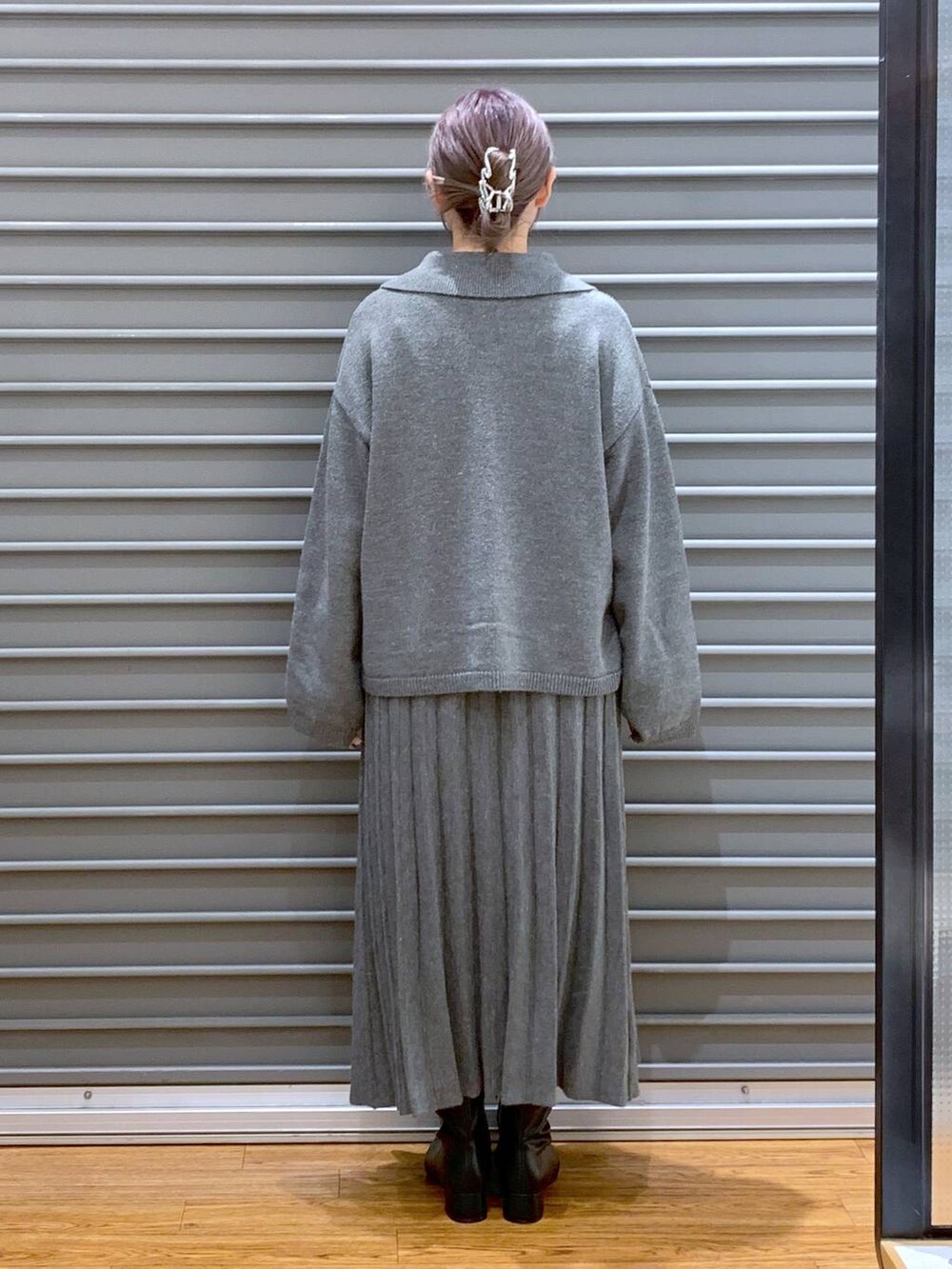 シルバー系のショルダーバッグ、ブラック系のブーツ、グレー系のワンピースを着用したレディースの秋コーディネートの2枚目の写真