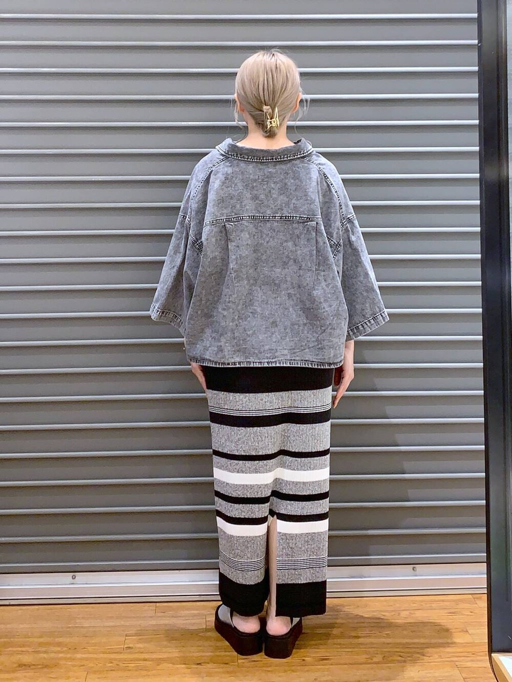 ブルー系のショルダーバッグ、ブラック系のシャツ/ブラウス、グレー系のサンダルを着用したレディースの春コーディネートの2枚目の写真