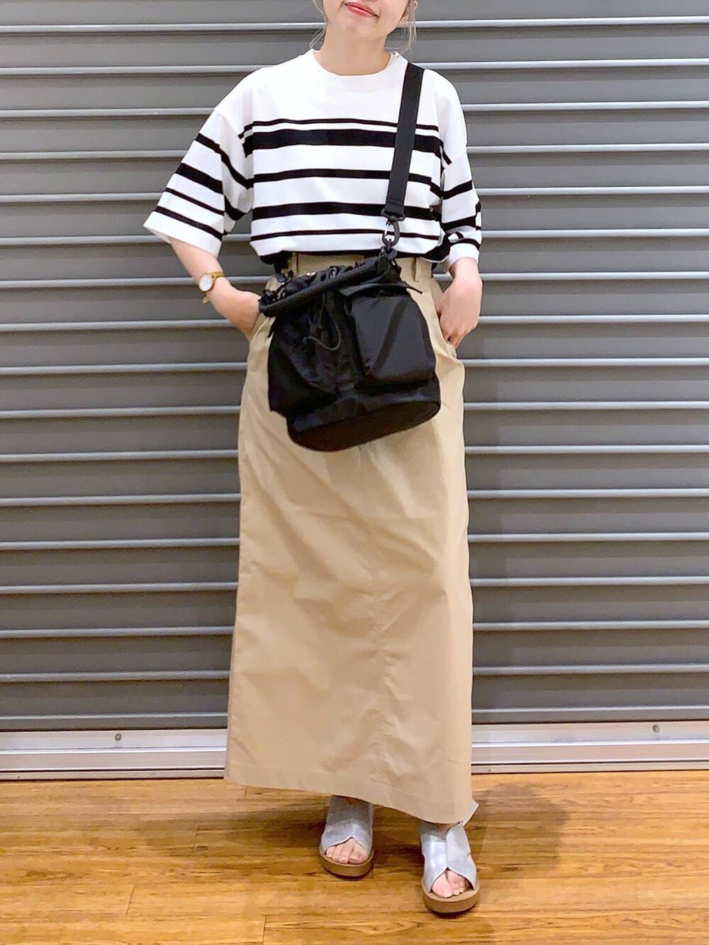 ベージュ系のスカート、シルバー系のサンダル、ホワイト系のニット/セーターを着用したレディースの夏コーディネートの4枚目の写真