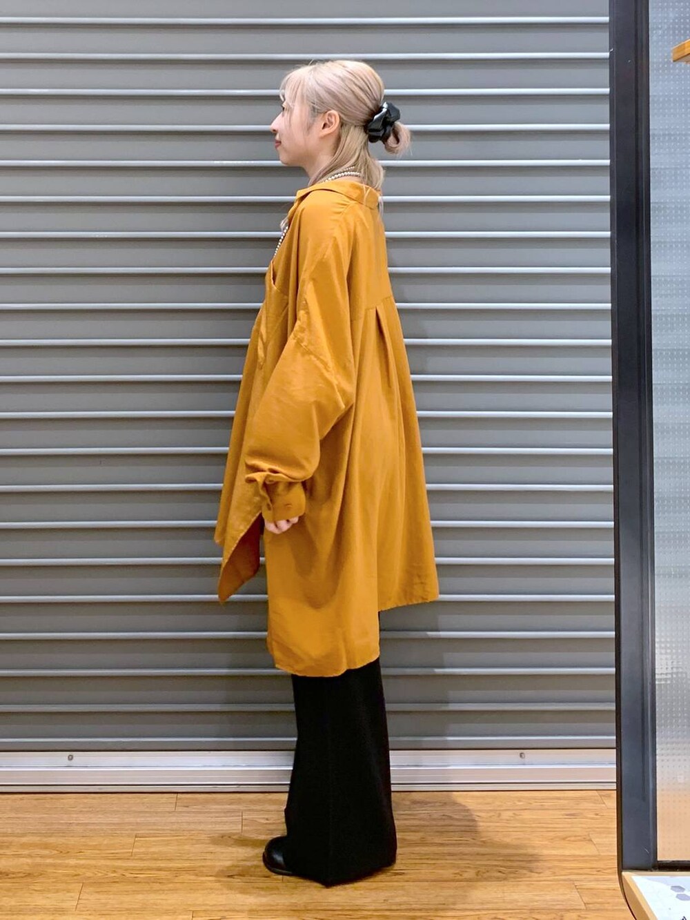 オレンジ系のシャツ/ブラウス、ブラック系のその他パンツ、グレー系のショルダーバッグを着用したレディースの秋コーディネートの3枚目の写真