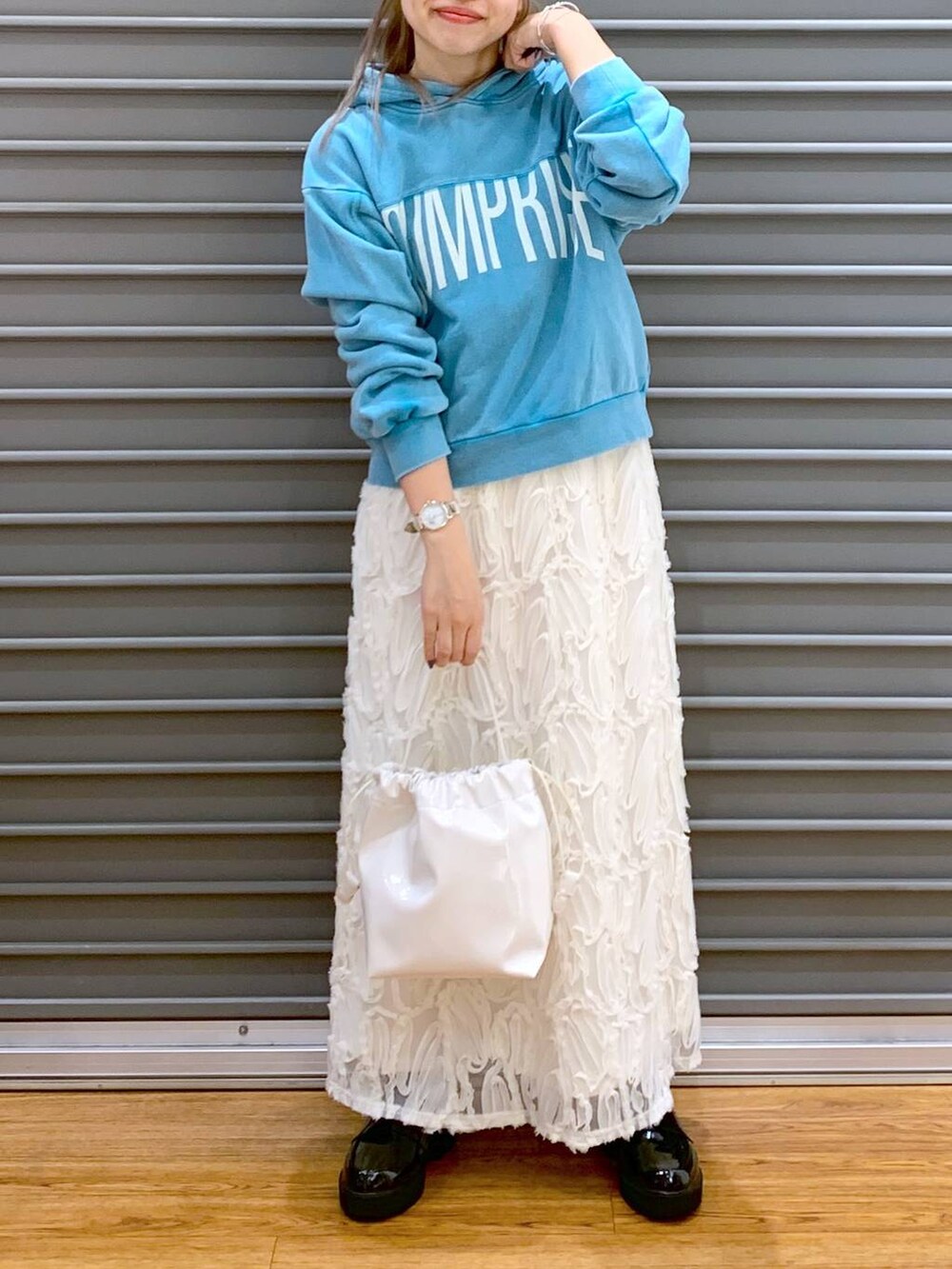 ブルー系のパーカー、ホワイト系のスカート、ブラック系のローファーを着用したレディースの冬コーディネートの5枚目の写真