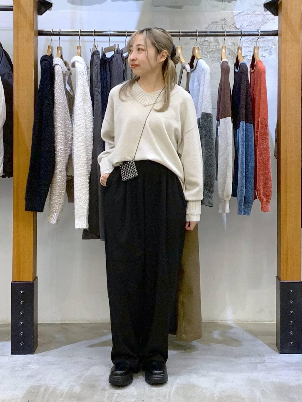 ブラック系のその他パンツ、ホワイト系のニット/セーター、ブラック系のブーツを着用したレディースの冬コーディネートの5枚目の写真