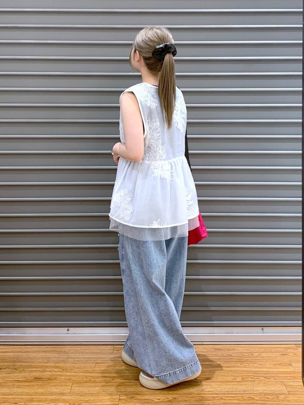 ブラック系のタンクトップ、ブルー系のデニムパンツ、ホワイト系のシャツ/ブラウスを着用したレディースの夏コーディネートの3枚目の写真
