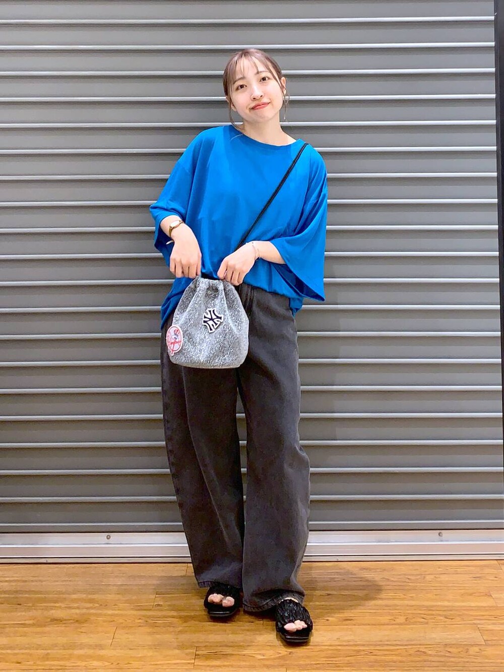 ブルー系のTシャツ/カットソー、グレー系のショルダーバッグ、ブラック系のデニムパンツを着用したレディースの夏コーディネートの5枚目の写真