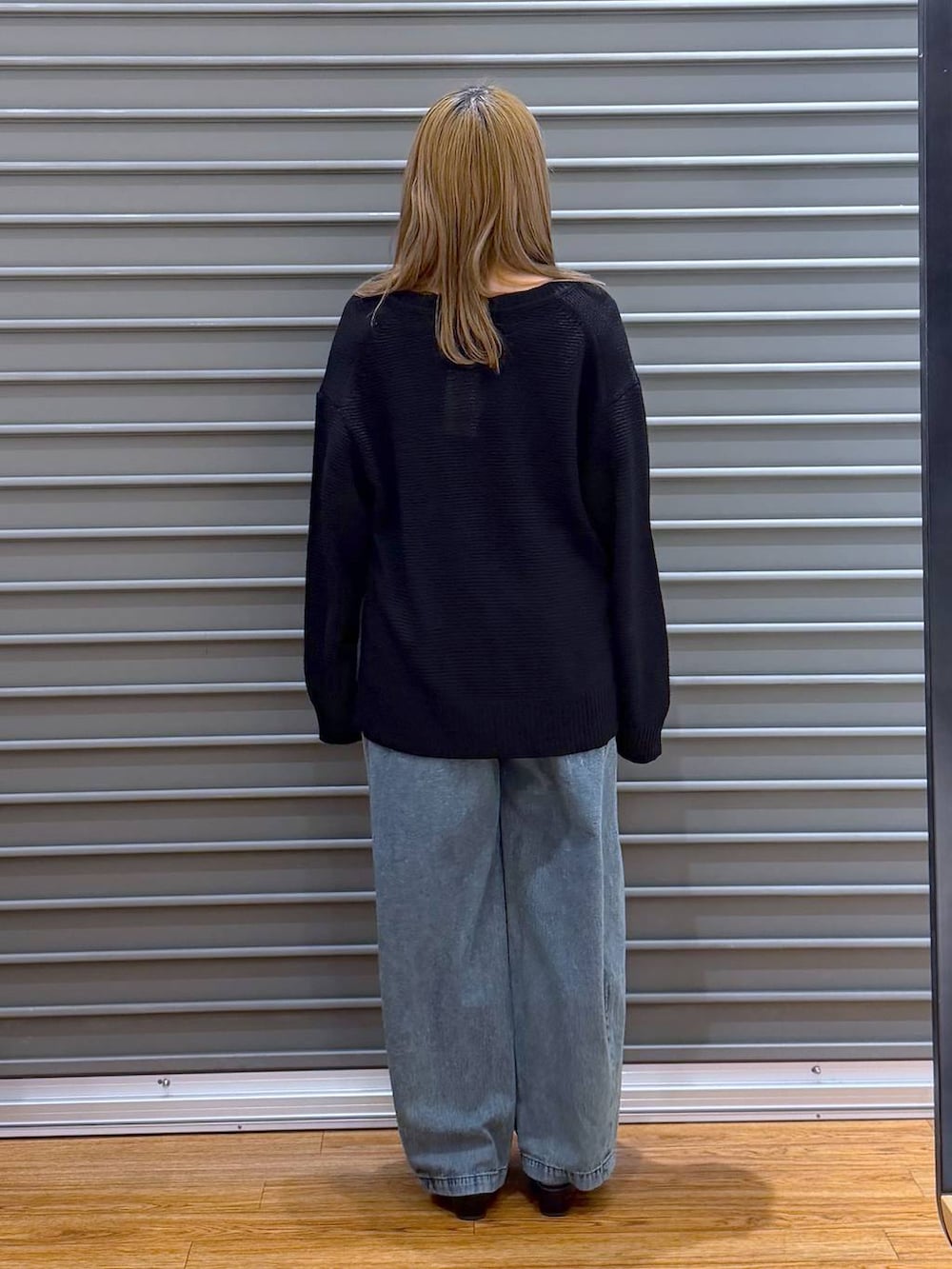 ブラック系のボストンバッグ、ブラック系のパンプス、ブルー系のデニムパンツを着用したレディースの春コーディネートの2枚目の写真