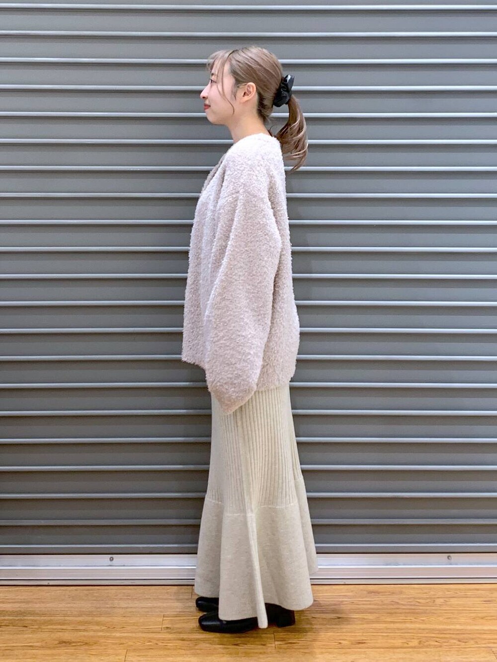 ブラック系のショルダーバッグ、ブラック系のブーツ、ホワイト系のワンピースを着用したレディースの冬コーディネートの3枚目の写真