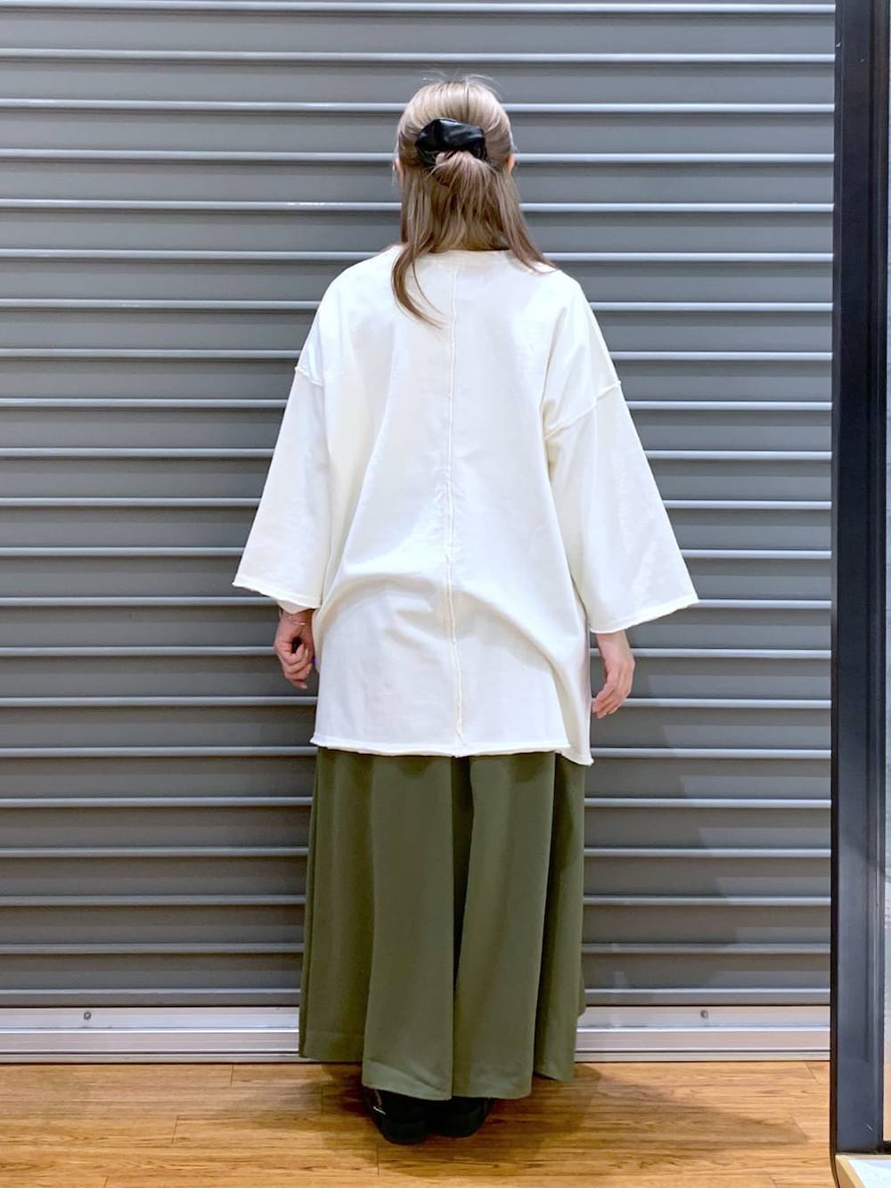 グリーン系のその他パンツ、ホワイト系のショルダーバッグ、ブラック系のサンダルを着用したレディースの春コーディネートの2枚目の写真