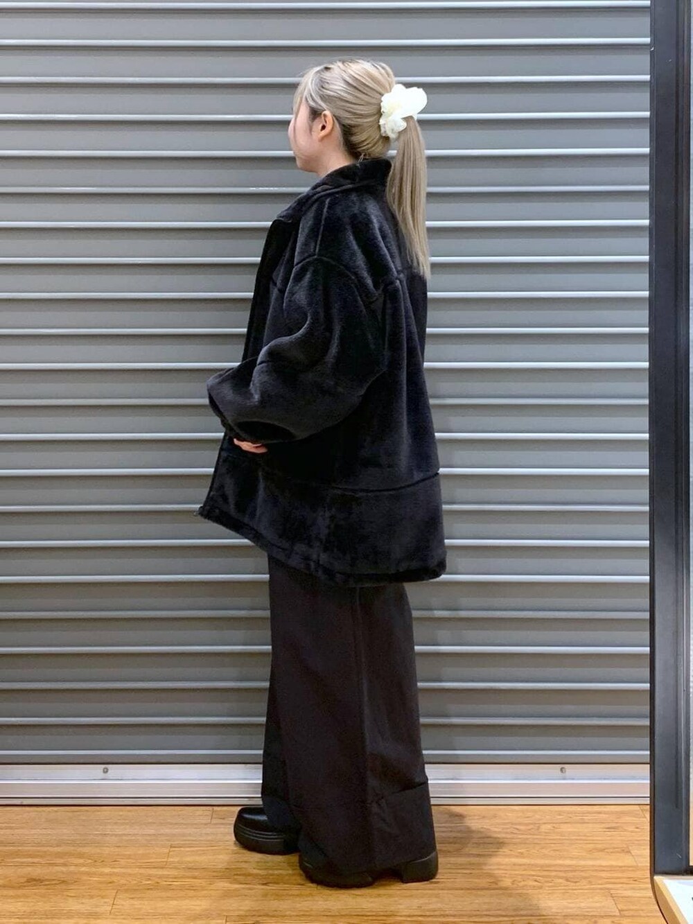 レッド系のニット/セーター、ブラック系のショルダーバッグ、ブラック系のブーツを着用したレディースの冬コーディネートの4枚目の写真